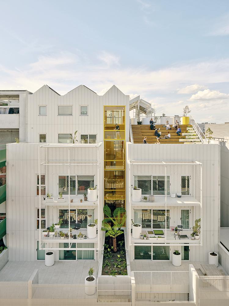 The Park Life residential building in Melbourne was planned for climate neutrality. Common spaces reach from the palm tree adorned bicycle garage below grade, to communication areas facing the
apartments and to the roof terrace.