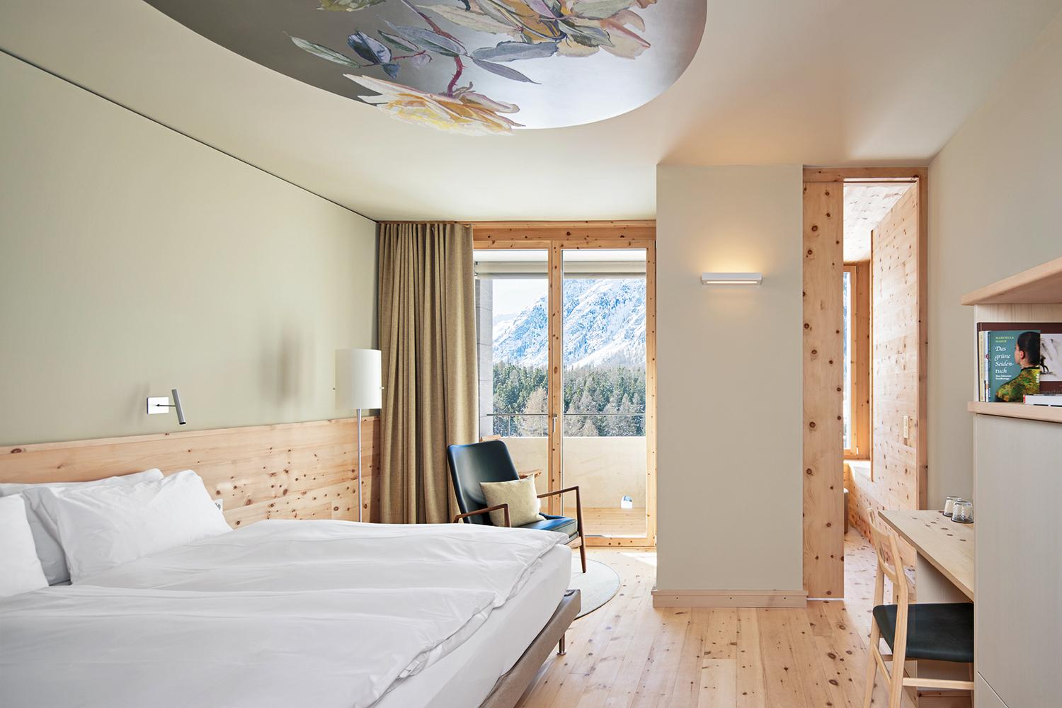 A view to the alpine world: Swiss pine wood and floral ceiling motifs reminiscent of a Grand Hotel provide the guestrooms with character.