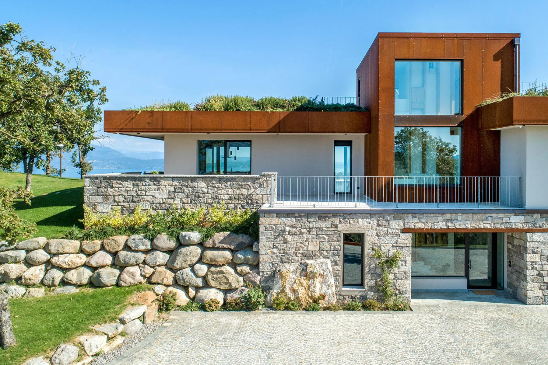 Die Geopietra-Verkleidung, mit einer regelmäßigen Textur und horizontalen Linien, verschönert diese prächtige Villa mit Blick auf den Gardasee.