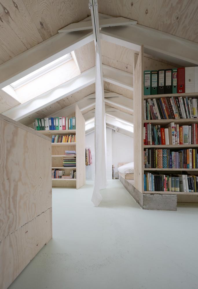 Mit sparsamen Mitteln haben die Architekten unter dem Dach des Reihenhauses nutzbaren Raum geschaffen. Der vorhandene Estrich wurde lediglich gestrichen, die Wellstegträger des Dachs und der Betonsockel unter Regal und Bett waren schon im Bestand vorhanden.