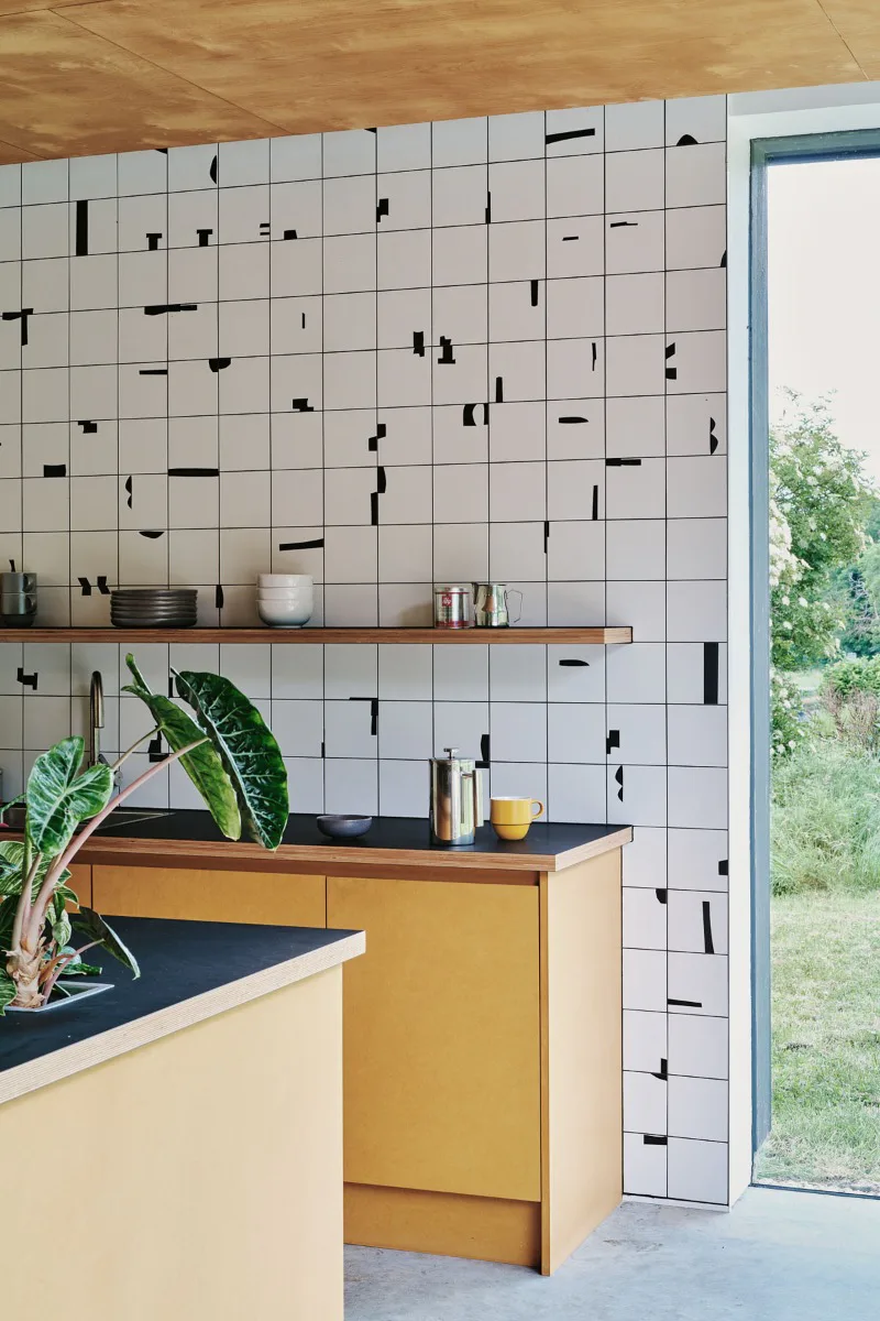 The kitchen, which is on the ground floor of the office building, opens onto the parking lot with corner glazing.