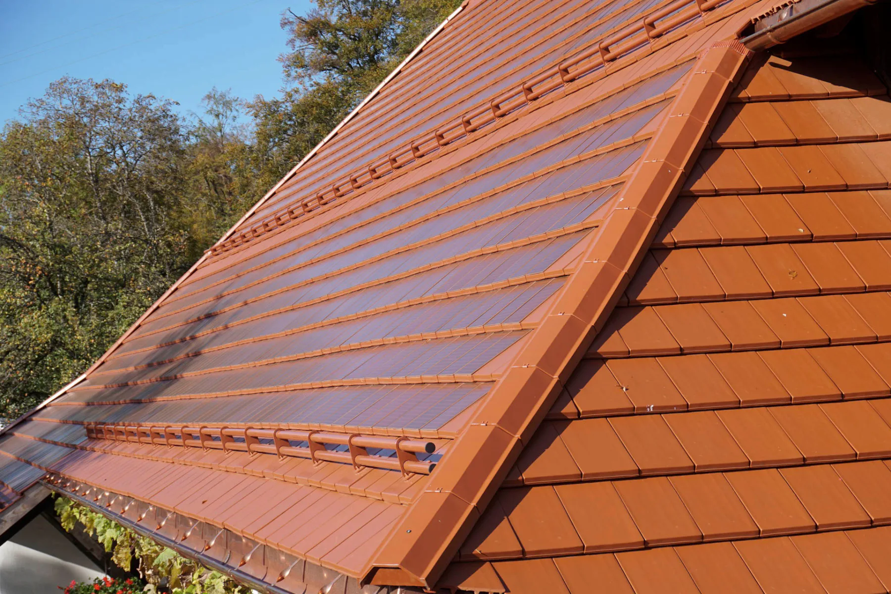 Der Solarziegel PV-Autarq ist nun auch in Kupferrot erhältlich. Er wird mit den Glattziegeln Domino von Creaton kombiniert.