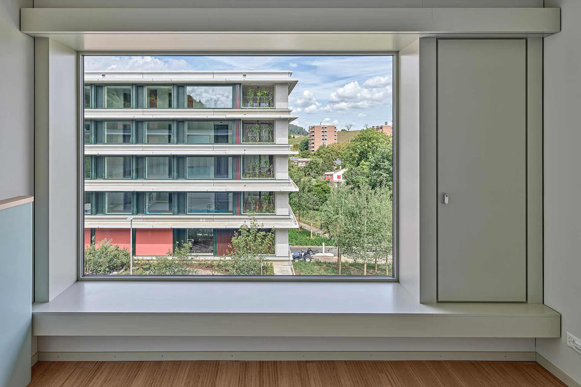 Mit niedrigen Brüstungen und tiefen Laibungen vermitteln die Fenster der Patientenzimmer Geborgenheit und Naturkontakt – Letzteren auch vom Bett aus.