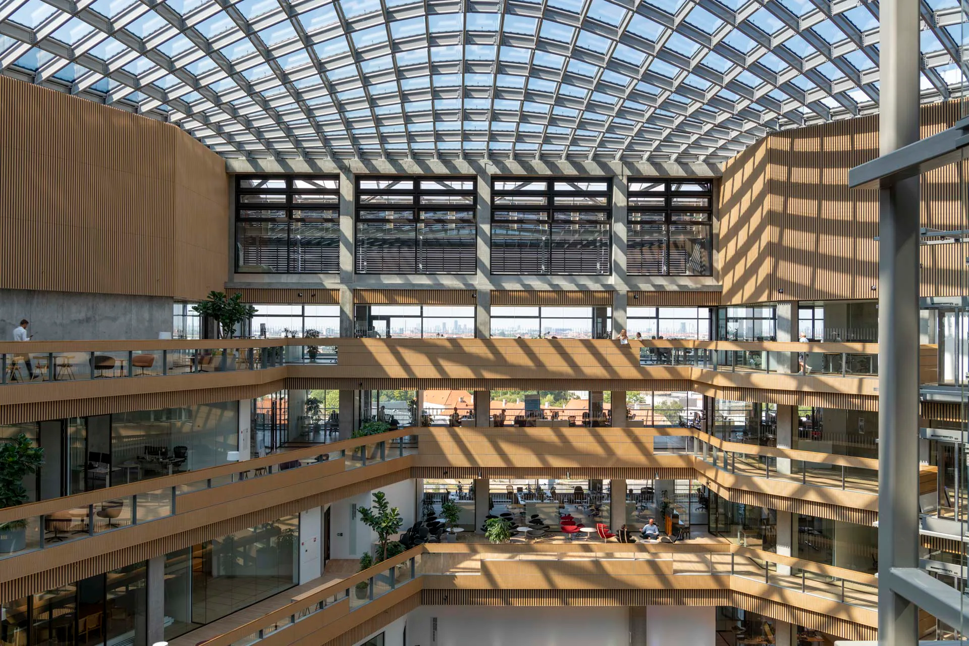 Ein annähernd sechseckiges Atrium mit Glasdach bildet den zentralen Treffpunkt für die bis zu 750 Mitarbeitenden im Haus.