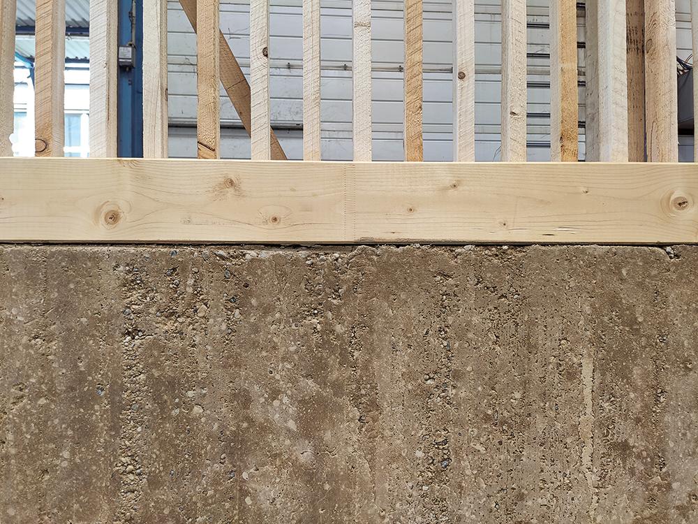 Verfüllter und unverfüllter Abschnitt des Deckenelements im Detail: Für eine natürliche Ästhetik wird auch die Lehmoberfläche der sichtbaren Unterseite rau gestaltet.