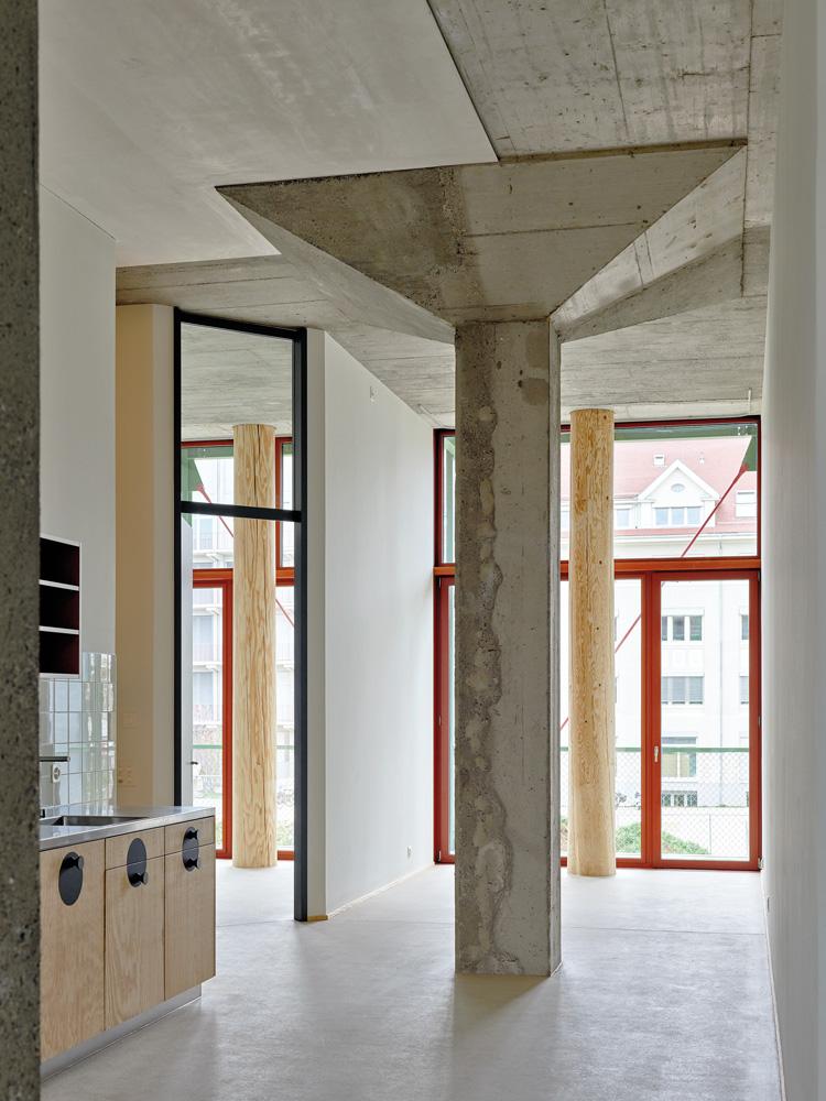 Die Pilzstützen des einstigen Lagerhauses stehen mitten in den Wohnräumen. Als Fassadenstützen verwendeten die Architekten geschälte Baumstämme.