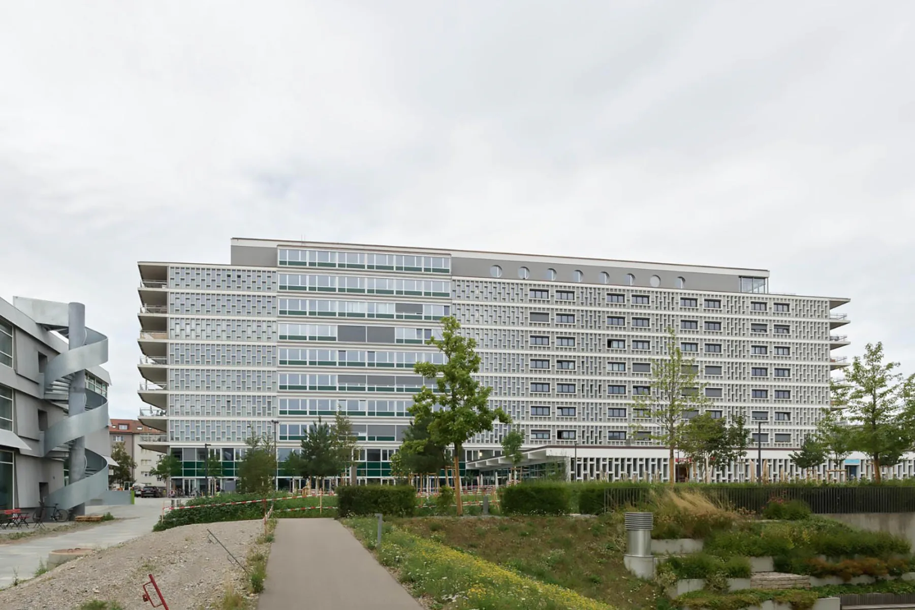 Der 100 m lange und 35 m hohe Betonriegel wurde nach Plänen der Architekten Fritz Rickenbacher und Walter Baumann errichtet.