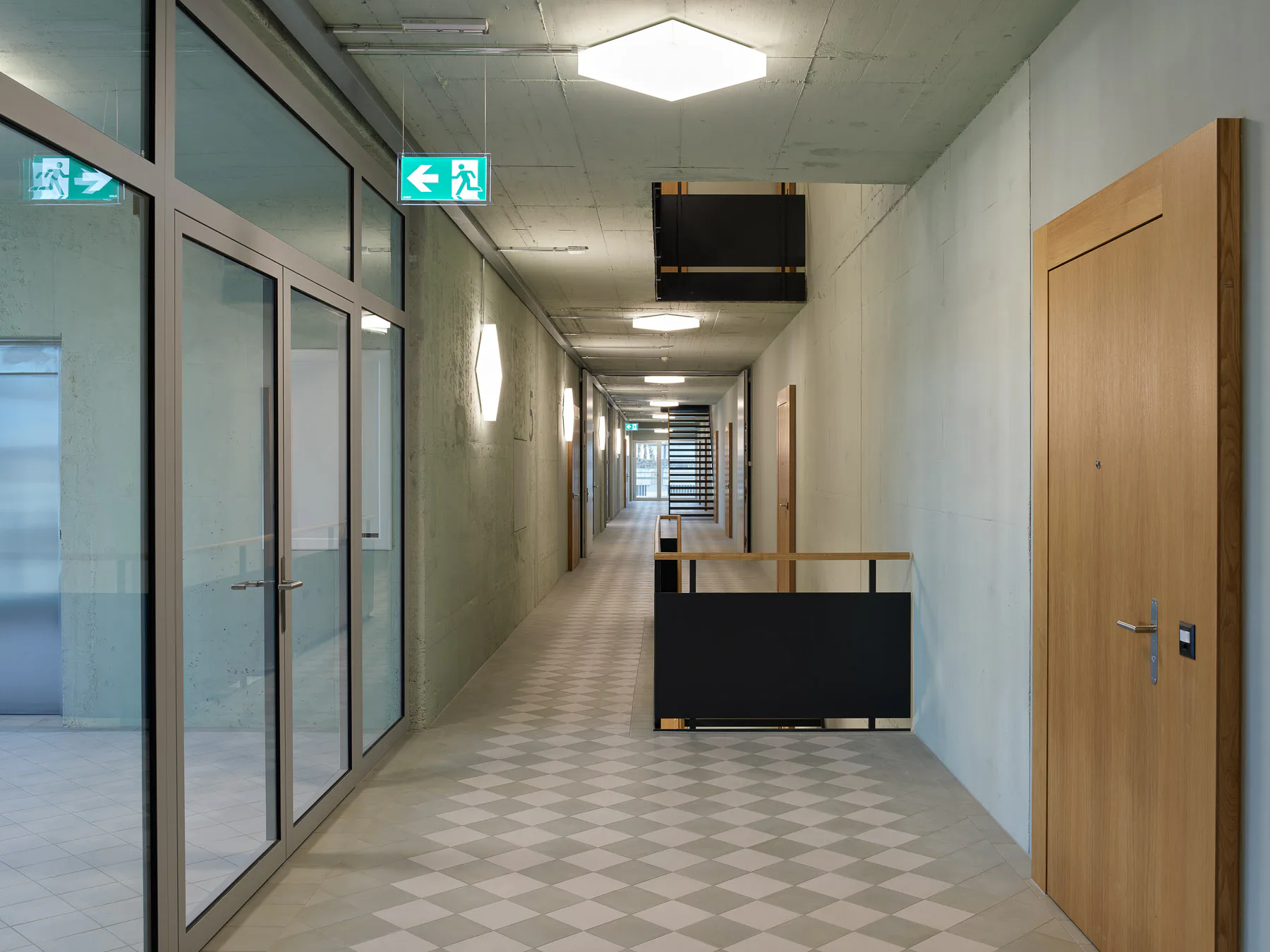 Gerade Treppenläufe und nachbarschaftliche Begegnungszonen gliedern die breiten Klinikflure.