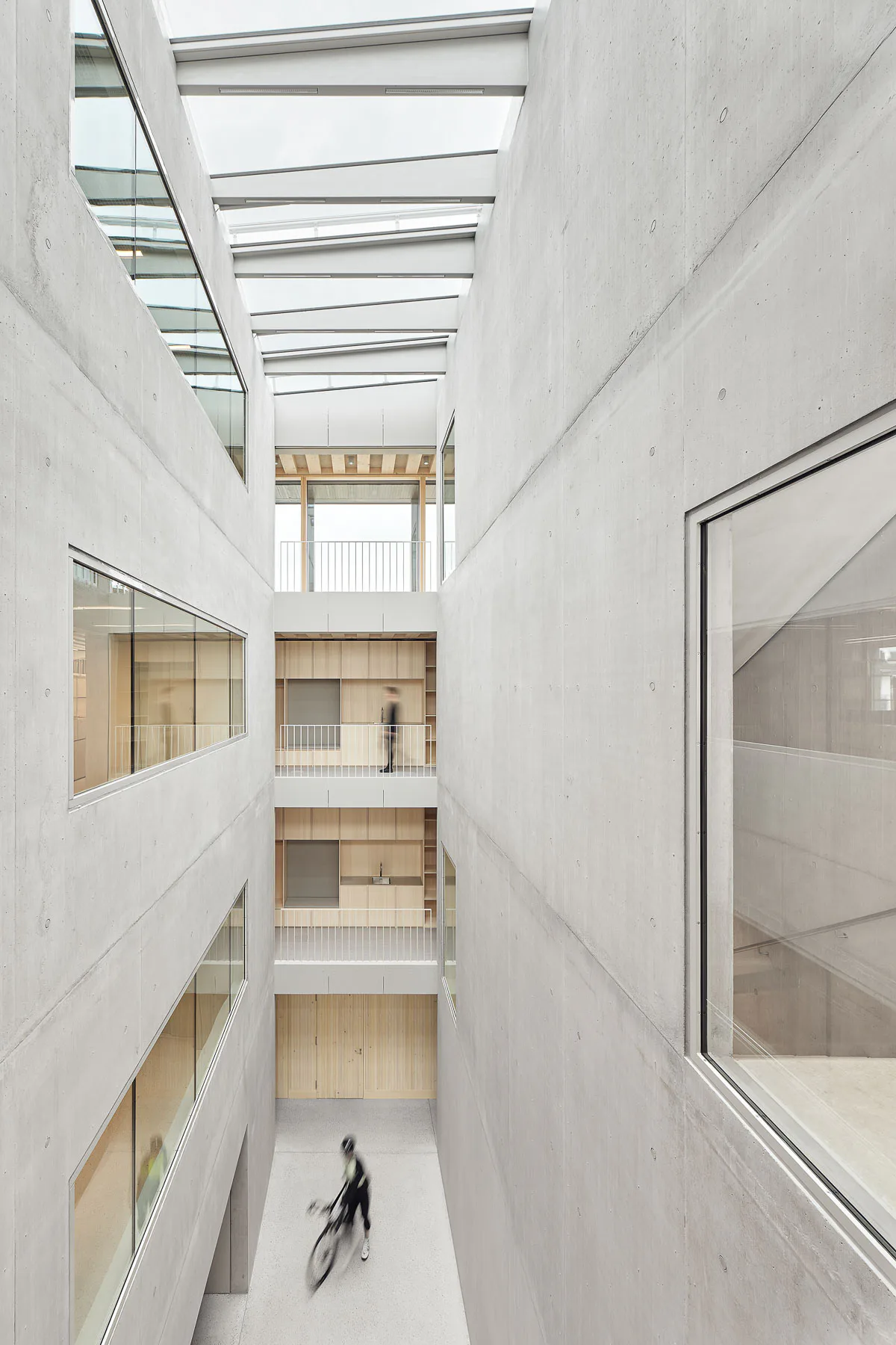 Das viergeschossige Atrium ist an den Längsseiten geschlossen und an den Stirnseiten offen. Mit Unterstützung des thermischen Auftriebs befördert es verbrauchte Luft ins Freie.