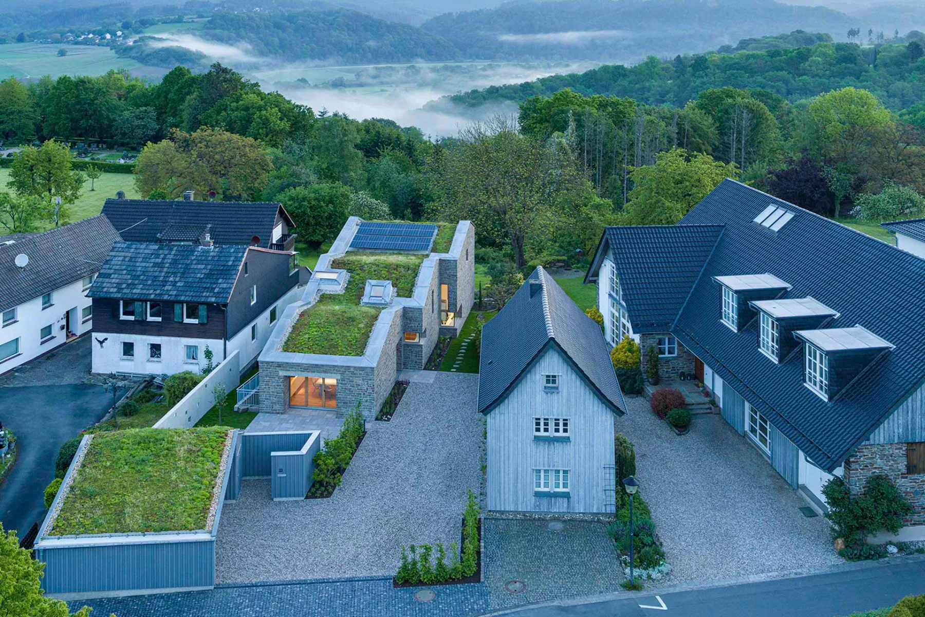 Das Atelierhaus für den Architekturfotografen HG Esch entwickelt sich in drei Abschnitten hangabwärts, wobei das größte und höchste Volumen den Schlusspunkt bildet.