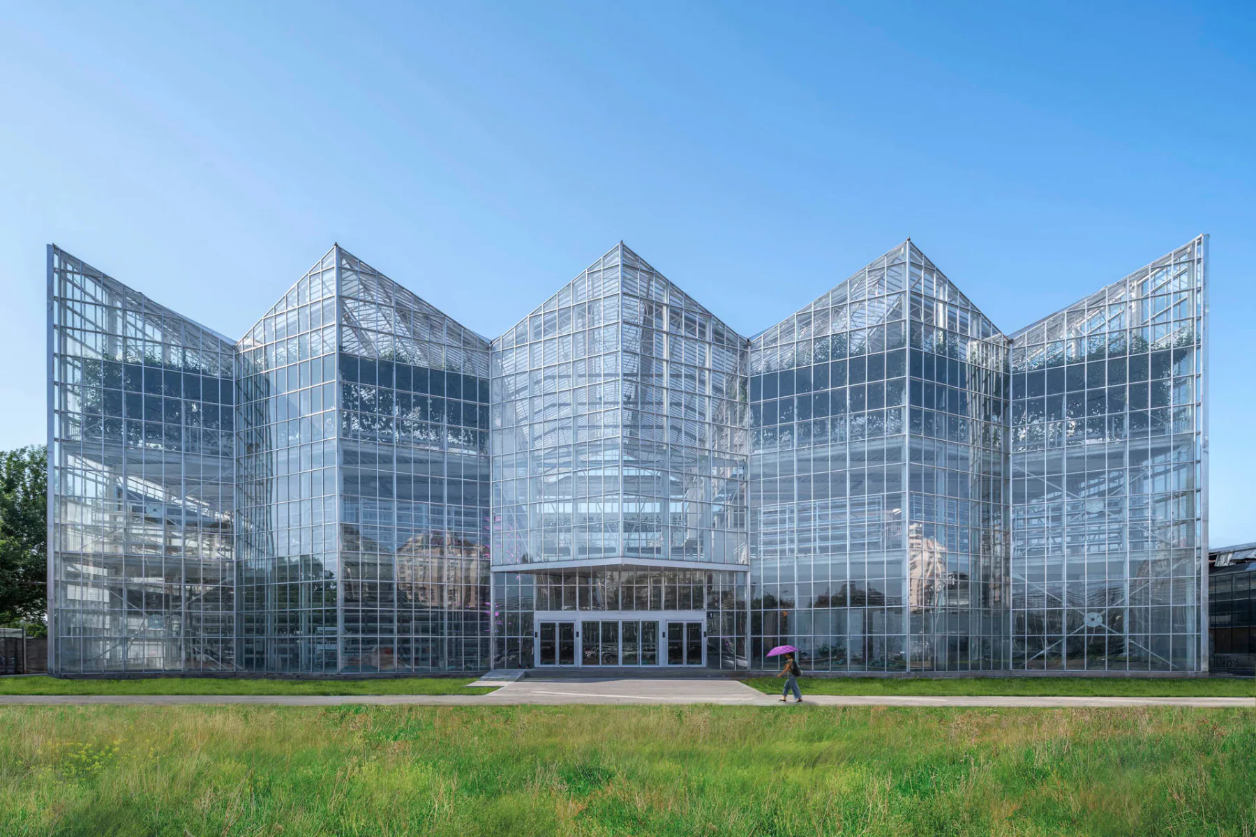Das dreistöckige Eingangsgebäude der Vertical Farm hat eine markante, gefaltete Glasfassade.