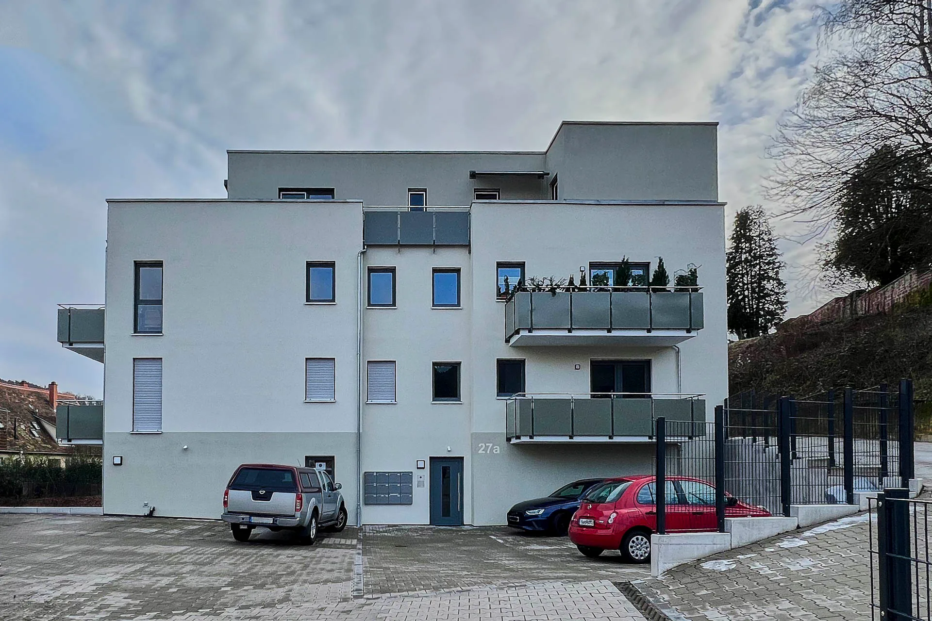 Das Mehrfamilienhaus mit zwölf Wohnungen steht auf einem Hanggrundstück.