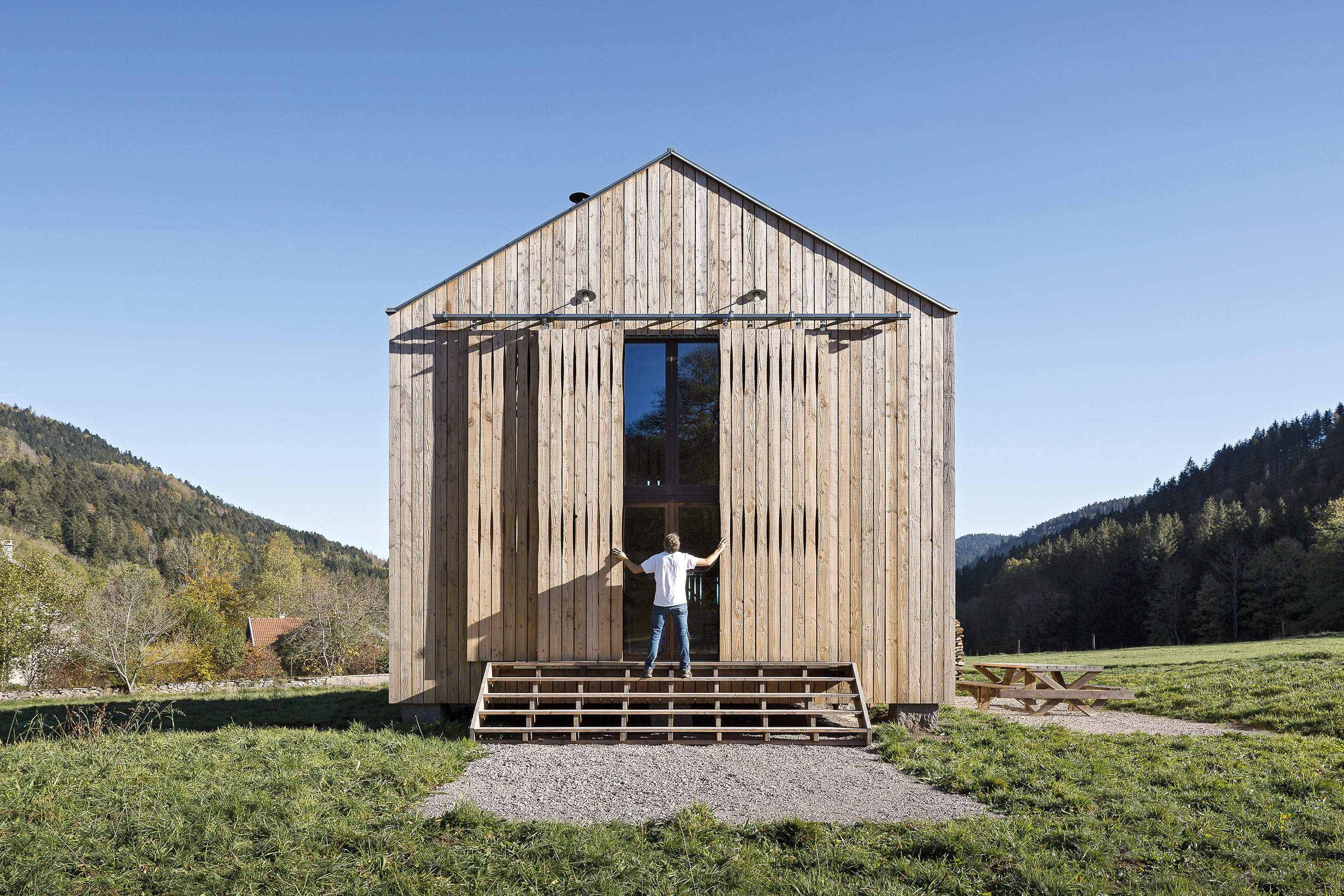 Wie eine bewohnbare Scheune steht das Ferienhaus auf einem Naturgrundstück in den Vogesen. Es ist aus Holz und Stroh gebaut, das aus der Umgebung stammt.