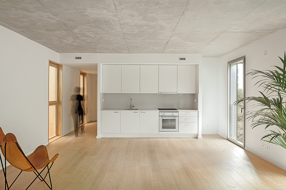 Im größten Raum mischen sich die Funktionen Kochen, Essen und Wohnen. Seine Orientierung zu Atrium und Stadt erlaubt das Querlüften und bringt viel Licht ins Innere.