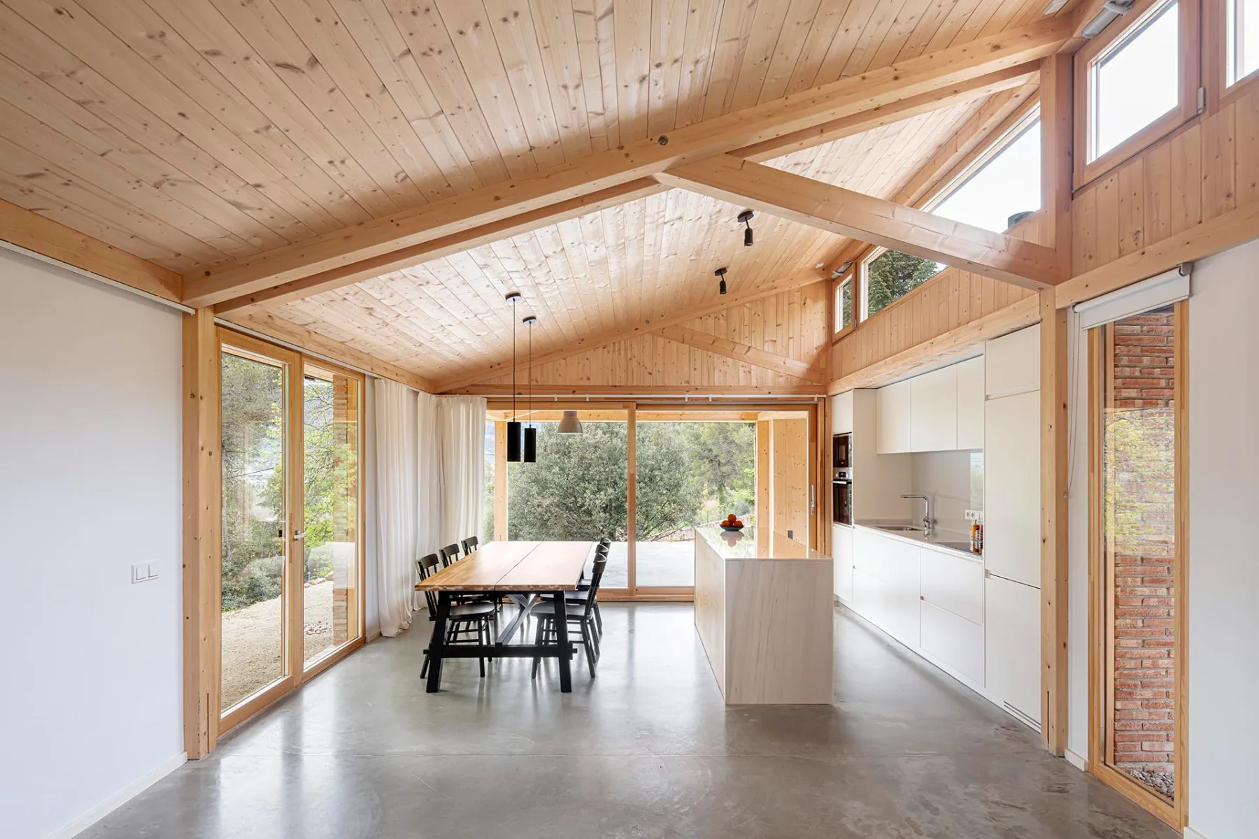Casa GE von Alventosa Morell Arquitectes: Die Leichtigkeit des Holztragwerks und der Kiefernholzverkleidung der Decke kontrastieren mit dem Mauerwerk.