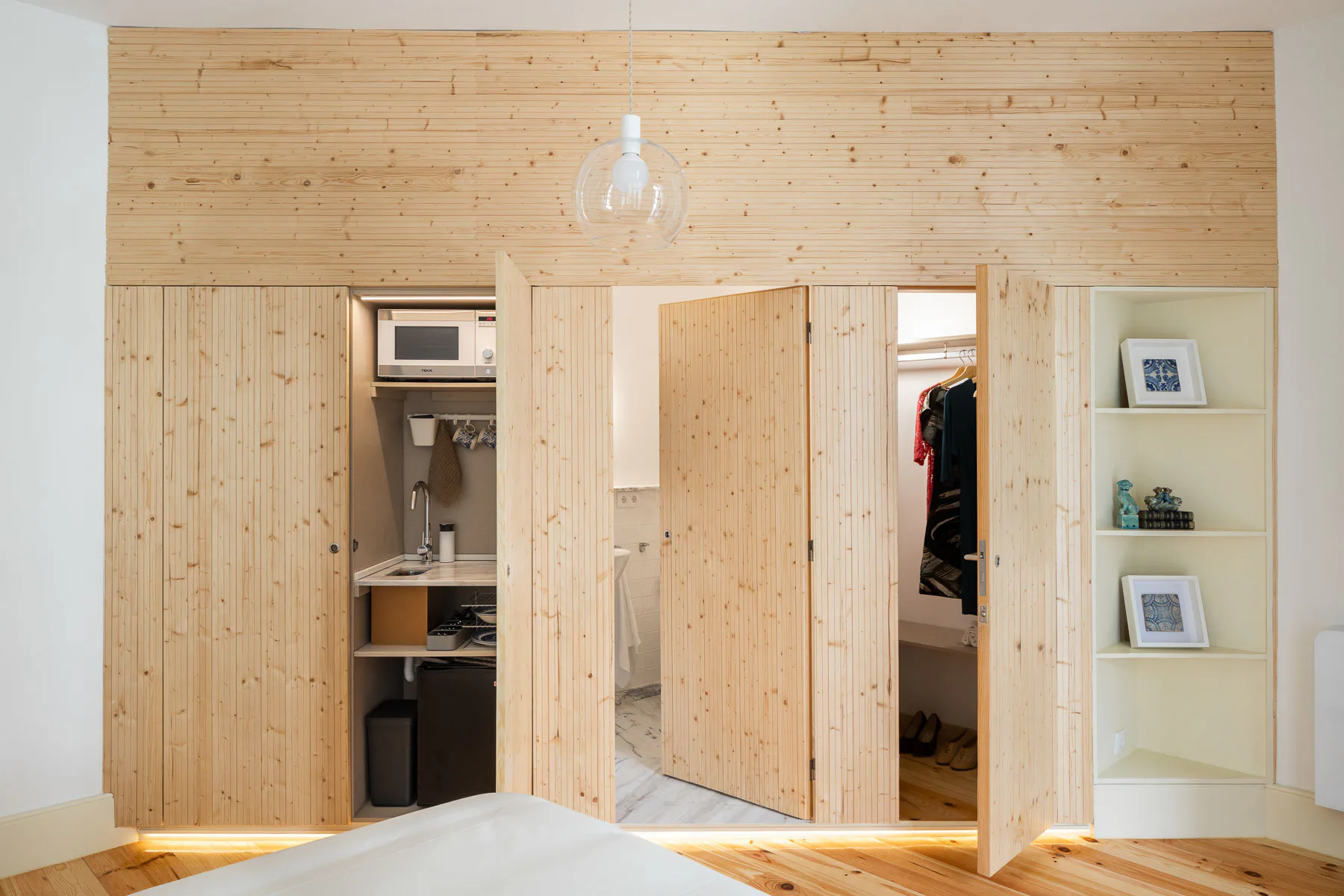 Räumliche Kerne in Dreiecksform verbergen dienende Bereiche wie Bad, Garderobe oder Kochnische.