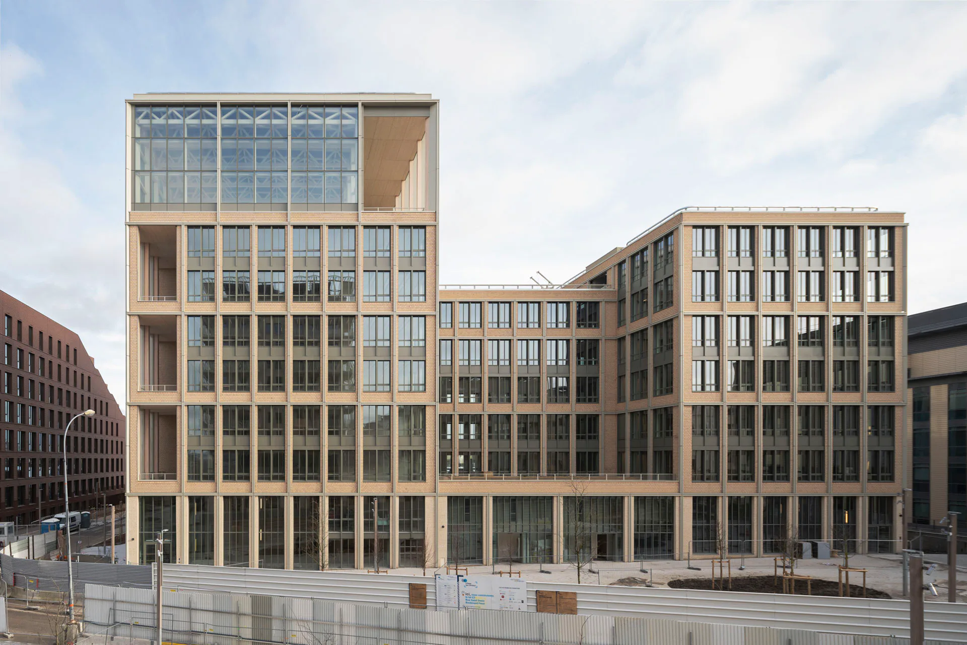 Bis auf das Erdgeschoss ist der Neubau in Holz-Hybridbauweise errichtet. Die Ziegelfassade soll an die industrielle Vorgeschichte des Standorts erinnern.
