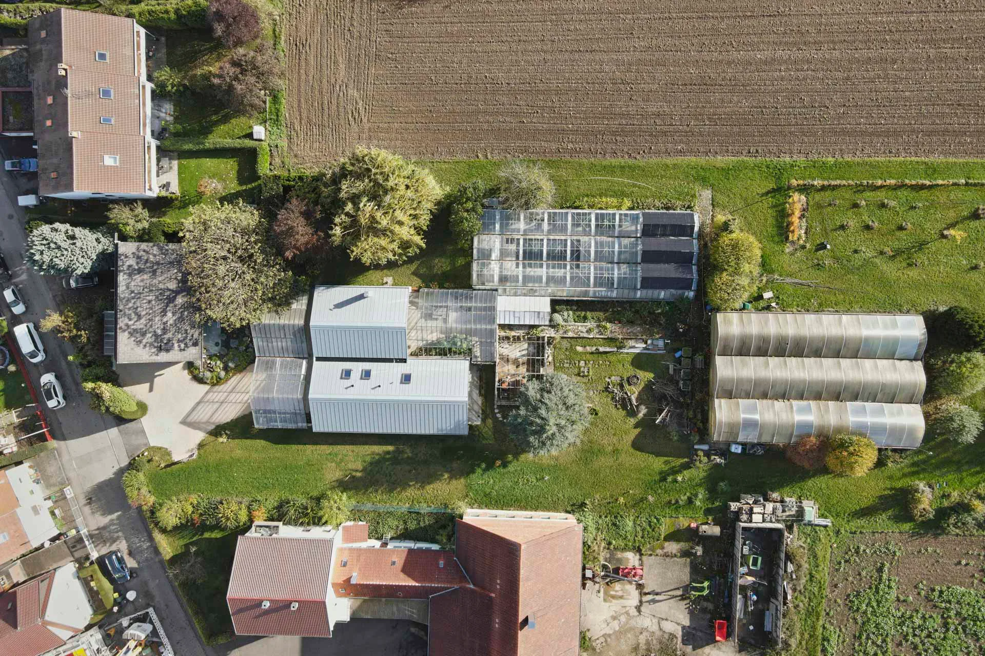 Aus der Luft wird die lineare Anordnung der Gebäude auf dem Grundstück sichtbar.