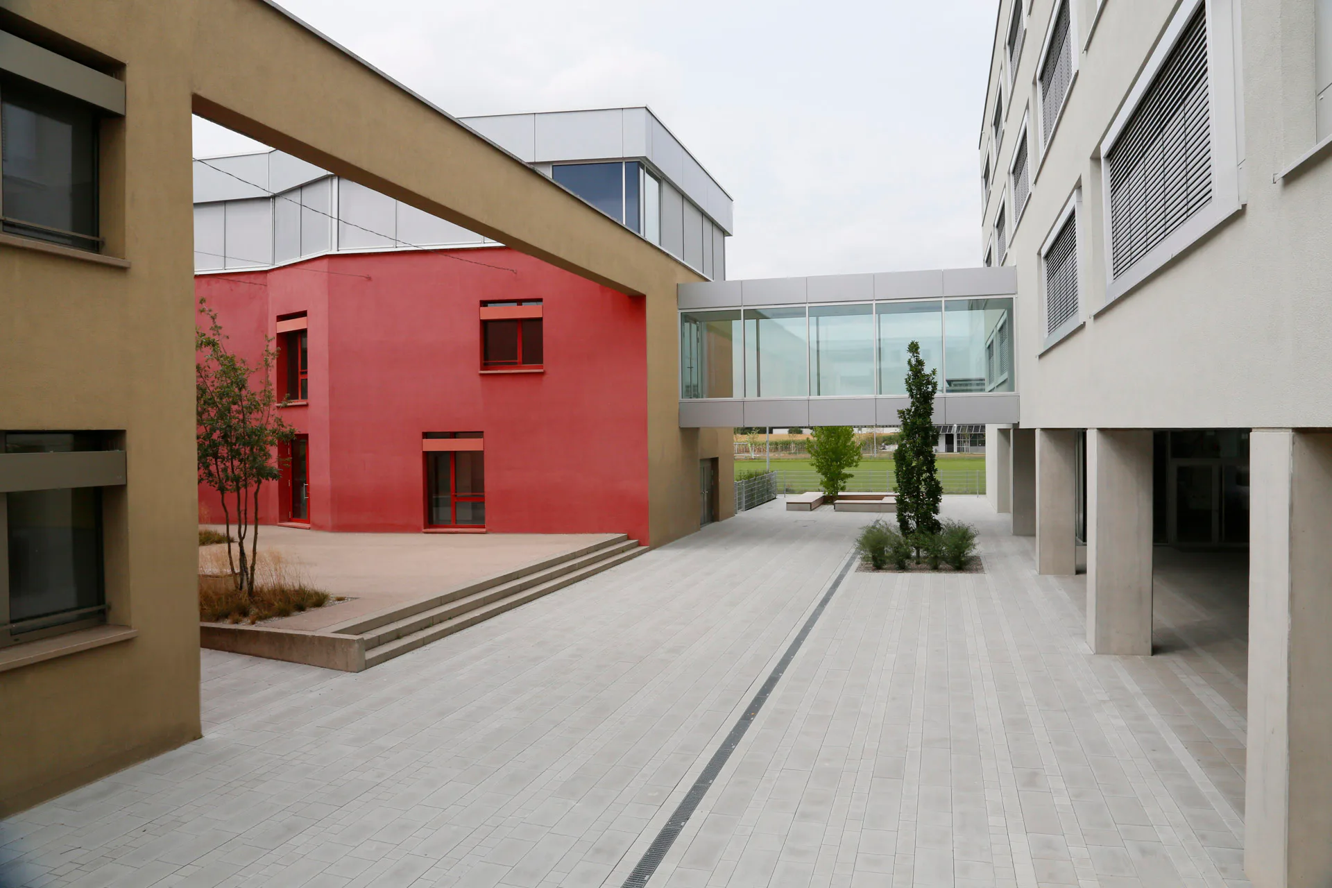 Im ersten Obergeschoss verbindet eine Brücke das alte und neue Schulgebäude miteinander.