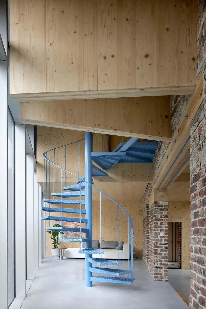 Im neuen Wohnbereich führt eine blaue Stahltreppe in das Obergeschoss.