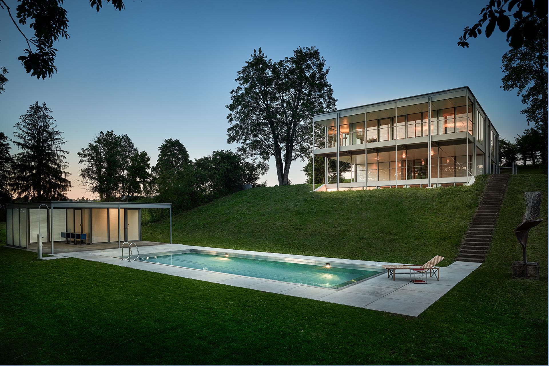 Blick vom Swimminpool und Poolhaus hinauf zum Haus.