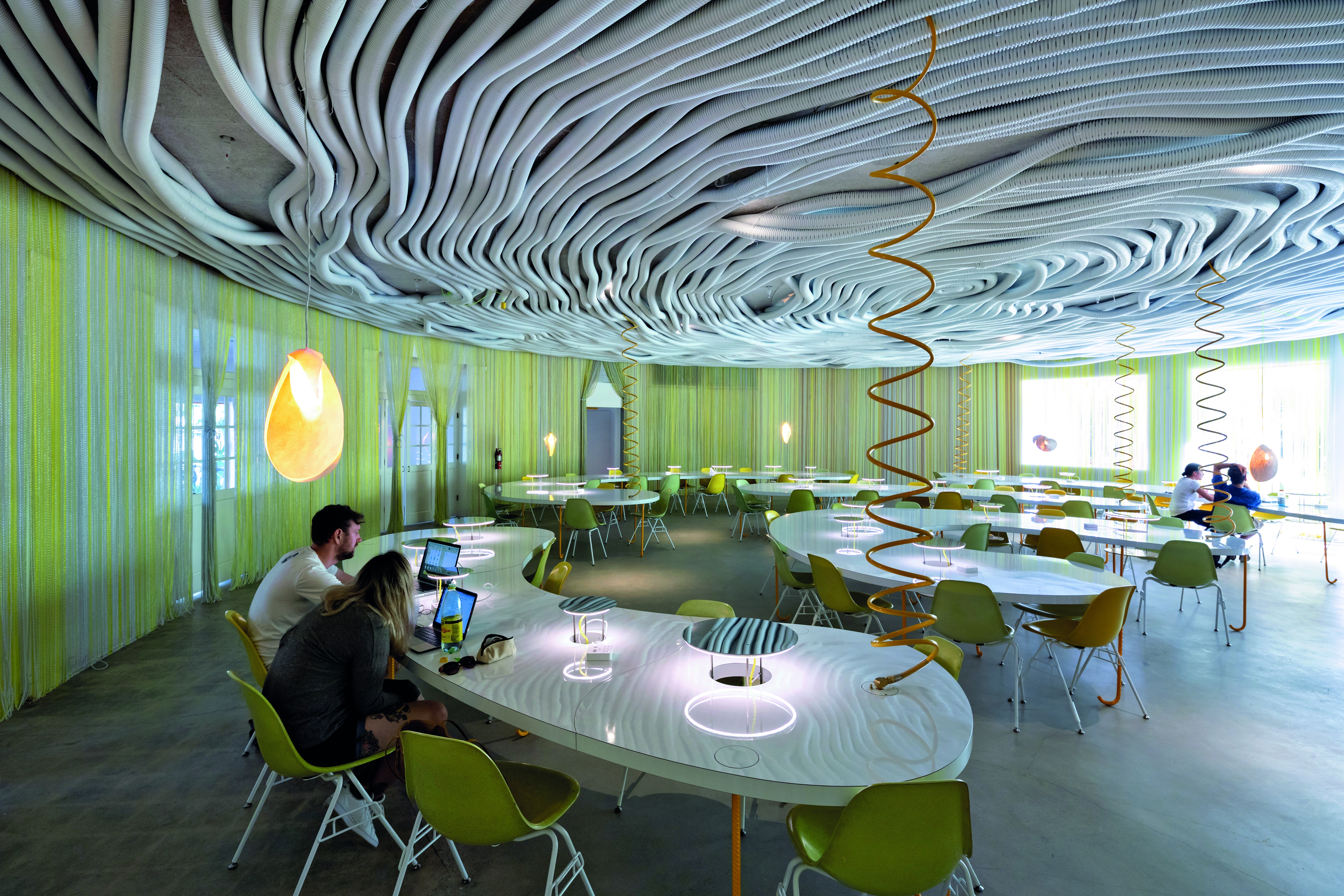 Eine unkonventionelle Arbeitsumgebung bietet der Co-Working Space Second Home in Los Angeles. An der Decke wirken Plastikschläuche als Schallabsorber und Verkleidung für die Verkabelungen.