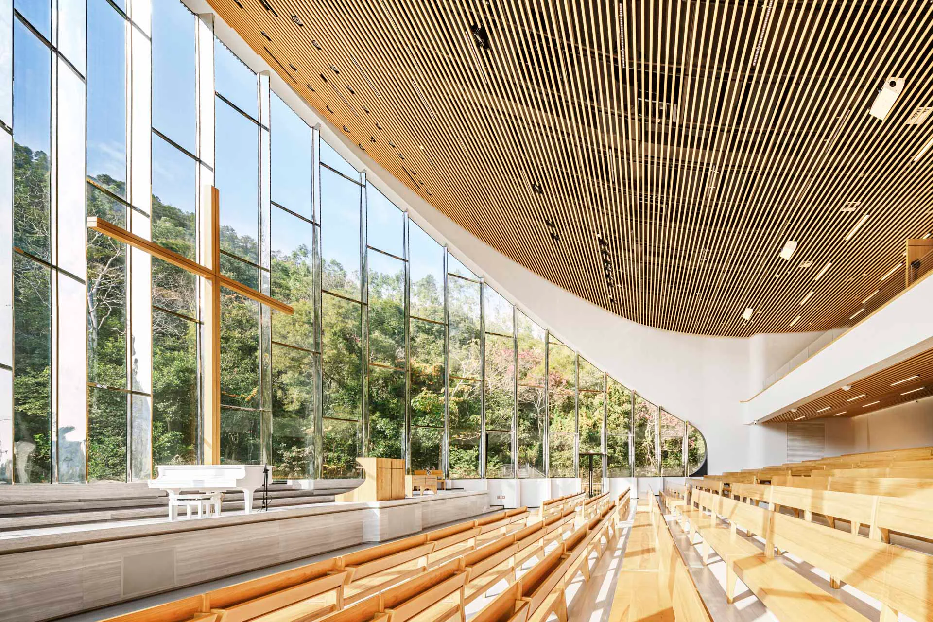 Mit großen Glasflächen öffnet sich der Kirchenraum zum Bergpanorama.