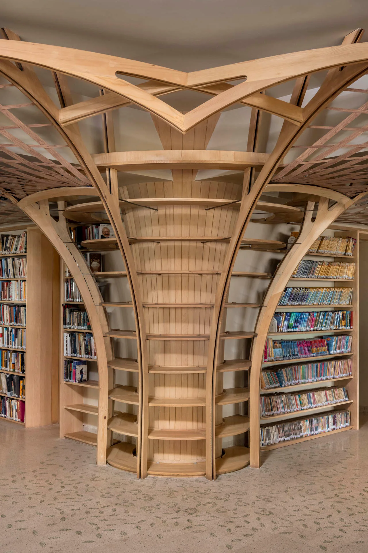 Die vorhandenen Betonsäulen sind mit Bücherregalen aus Holz ummantelt.