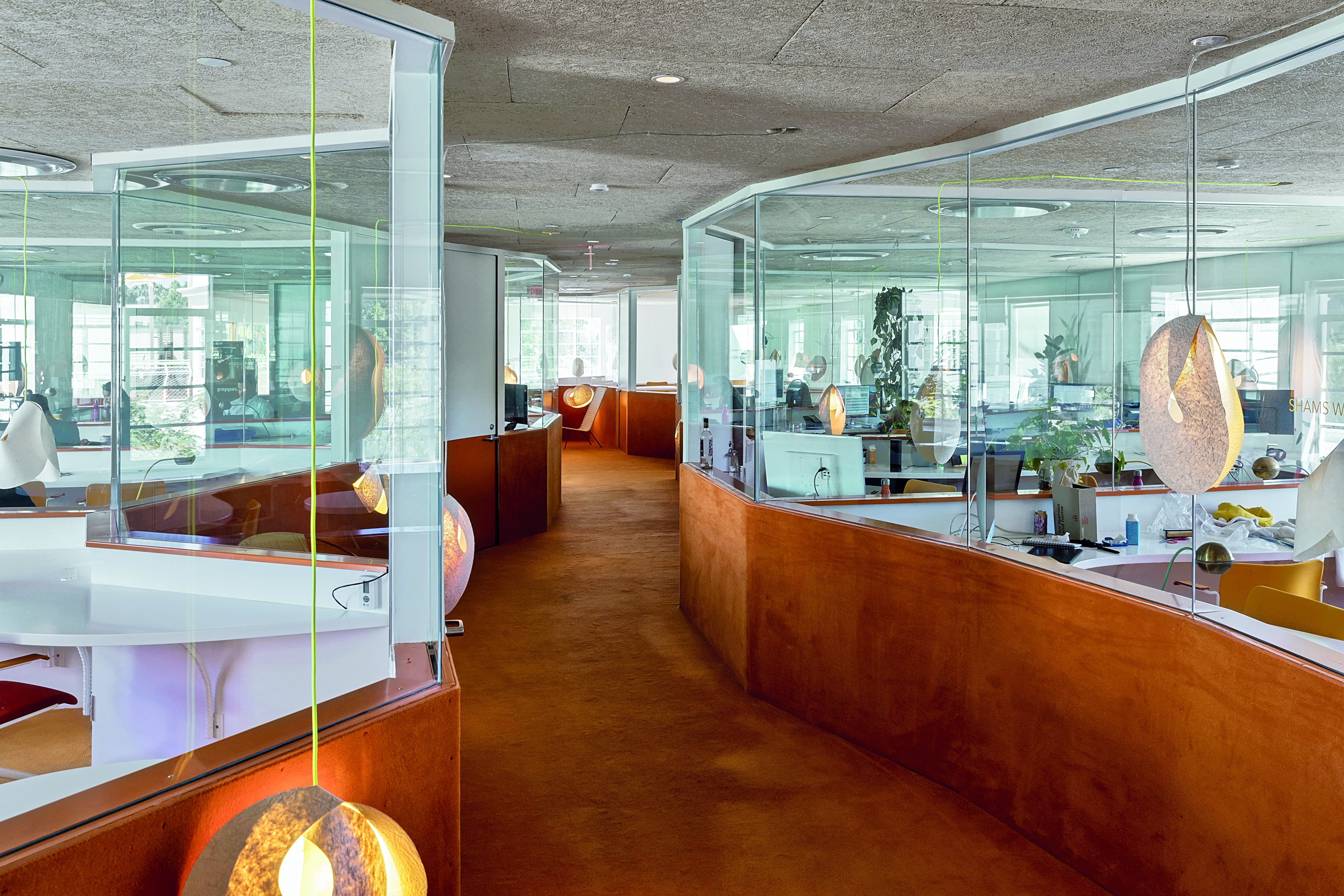 Bestandsgebäude der Second Homes von Selgascano sorgen orange Hochflorteppiche für eine anregende Arbeitsatmosphäre.