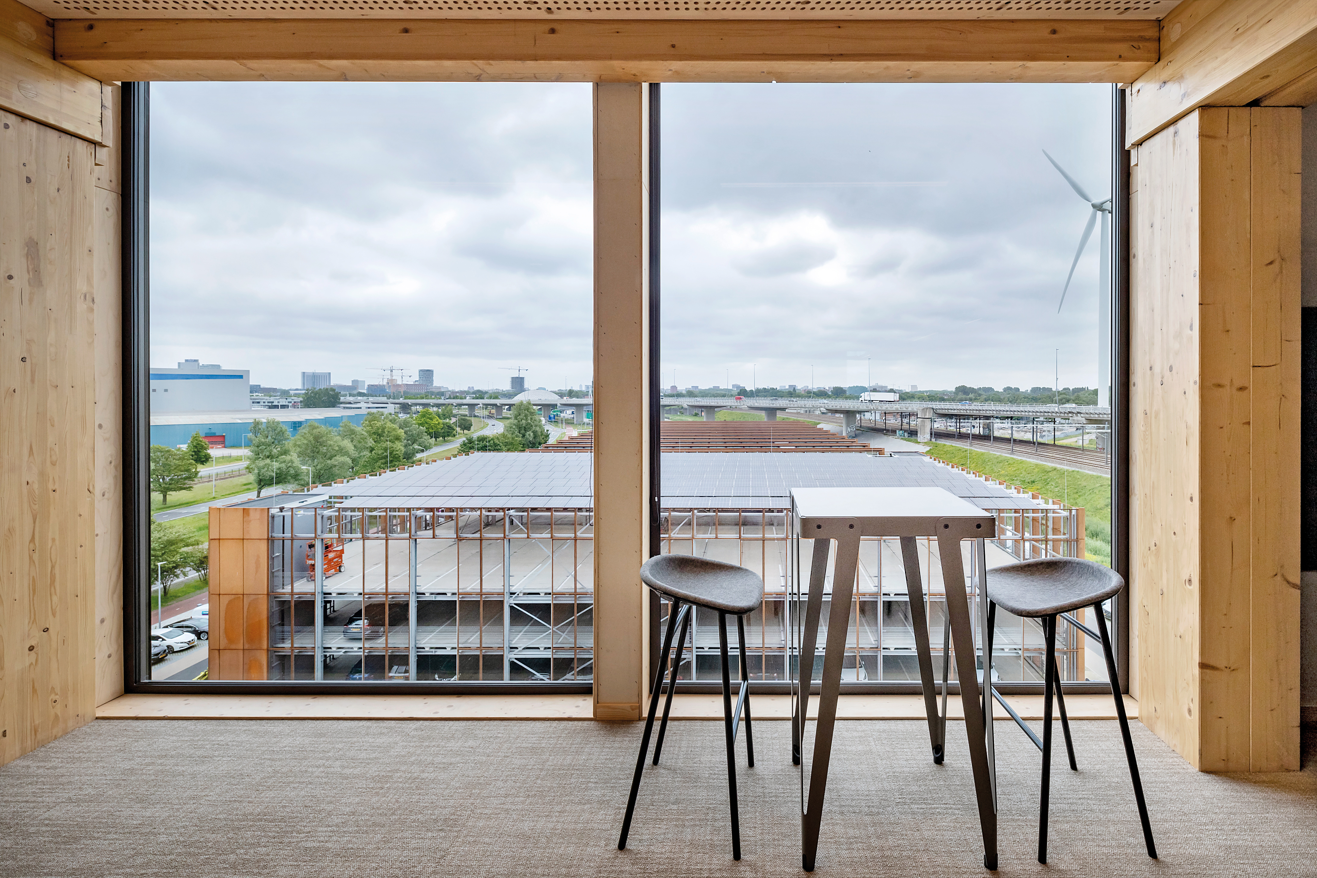 Mit acht Geschossen ist Alliander Westpoort das bisher höchste Bürogebäude aus Holz in den Niederlanden. Aus den oberen Etagen fällt der Blick weit über das Amsterdamer Hafengebiet.