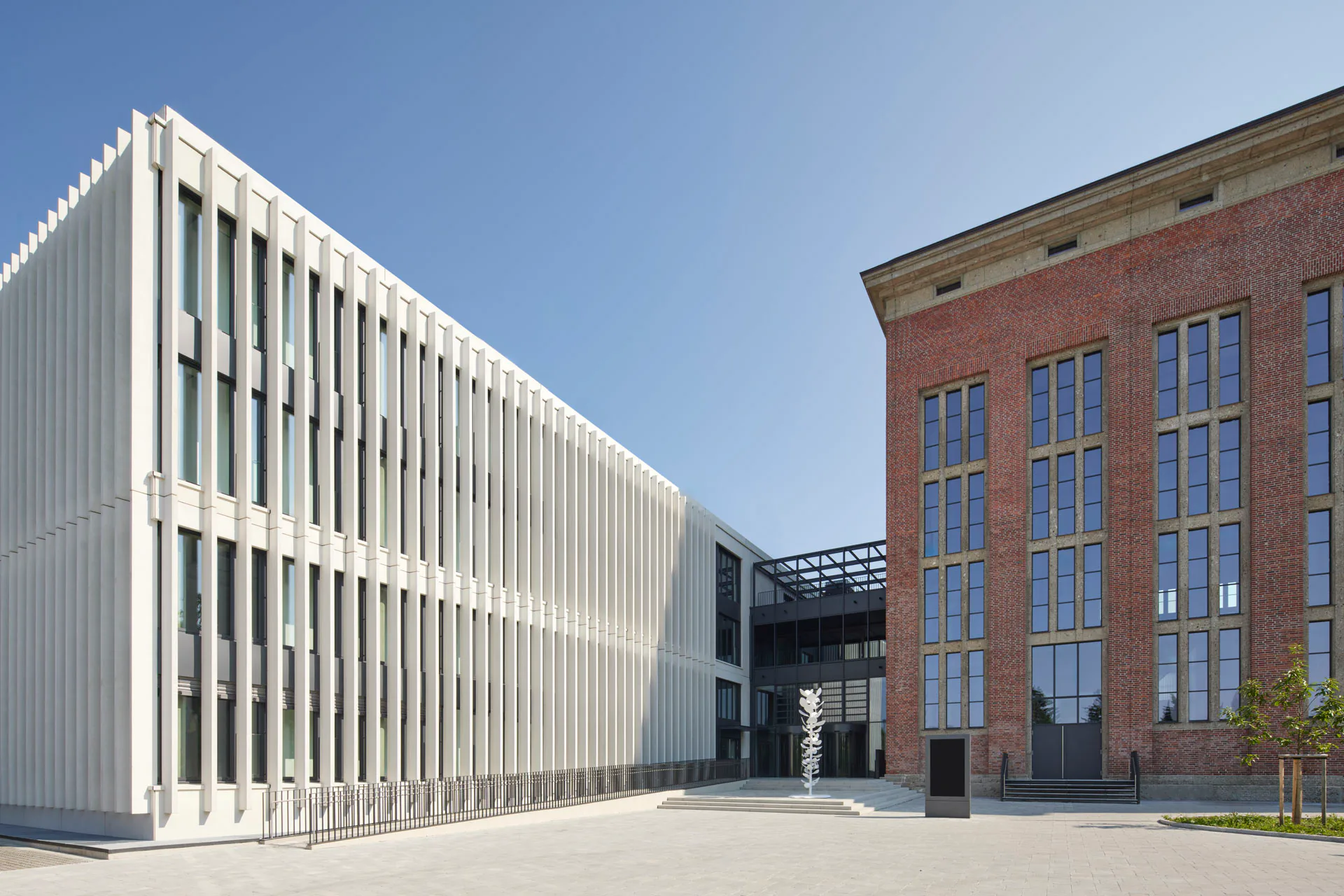 Nach Nordwesten haben die Architekten die Fassade des Bestands aufgebrochen. Über einen gemeinsamen Empfangsbereich schließt der Neubau an.