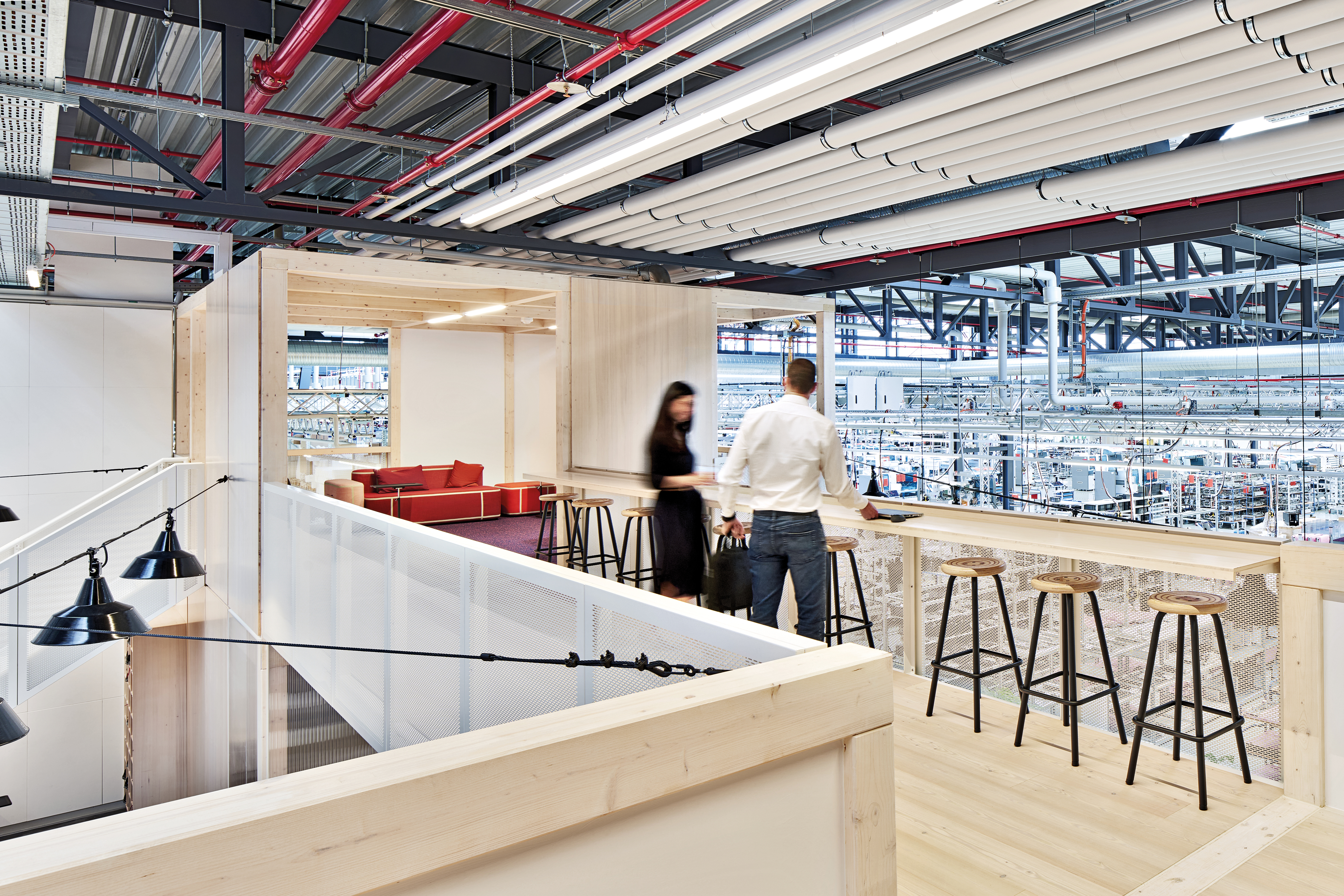 The connecting walkway features a bar, provides opportunities for informal encounter and offers a view of the adjacent production hall.