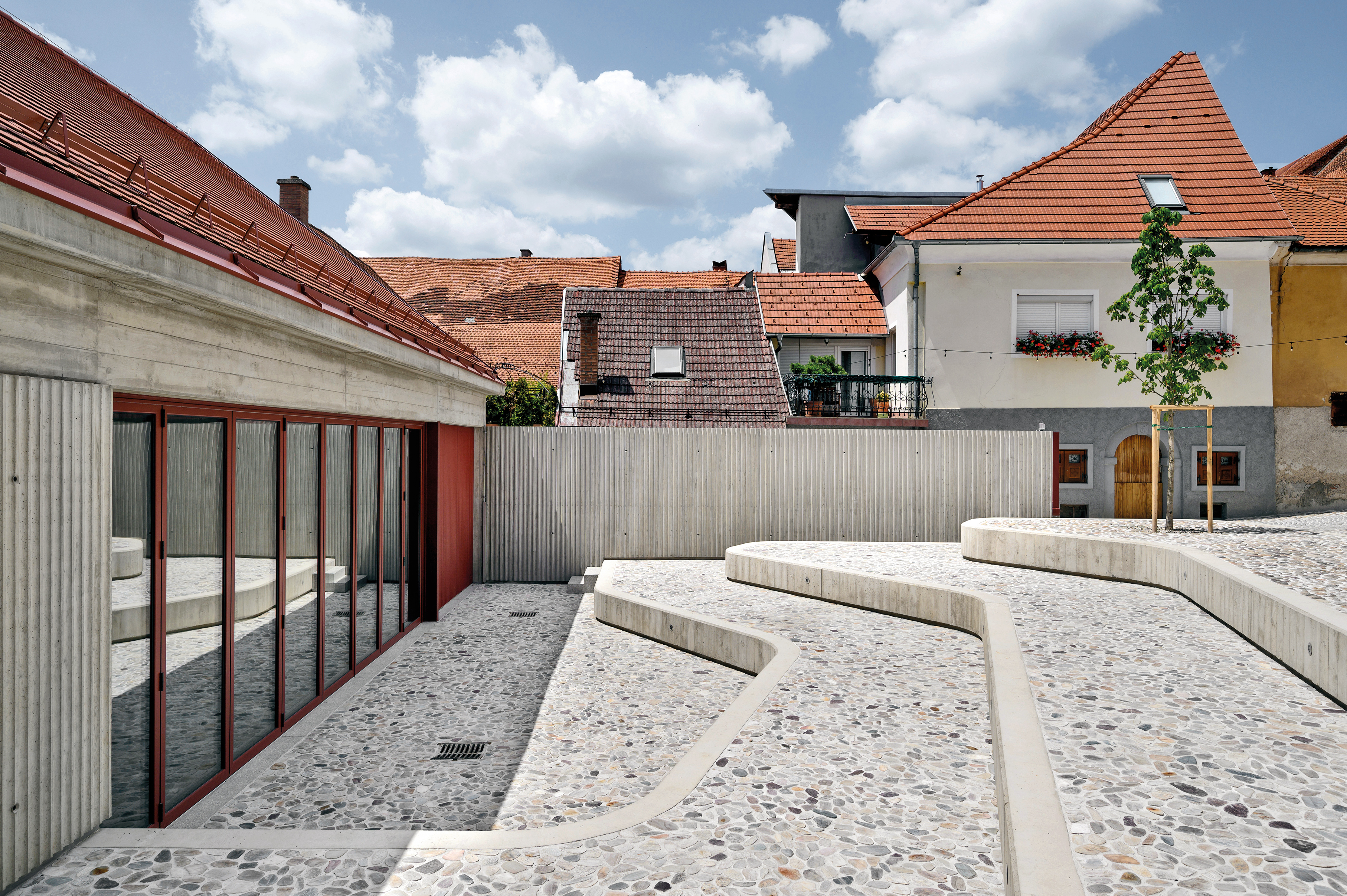 Die Glasfassade des großen Veranstaltungssaals lässt sich vollständig öffnen. Die Sitzstufen im Innenhof dienen dann als Zuschauerbereich.