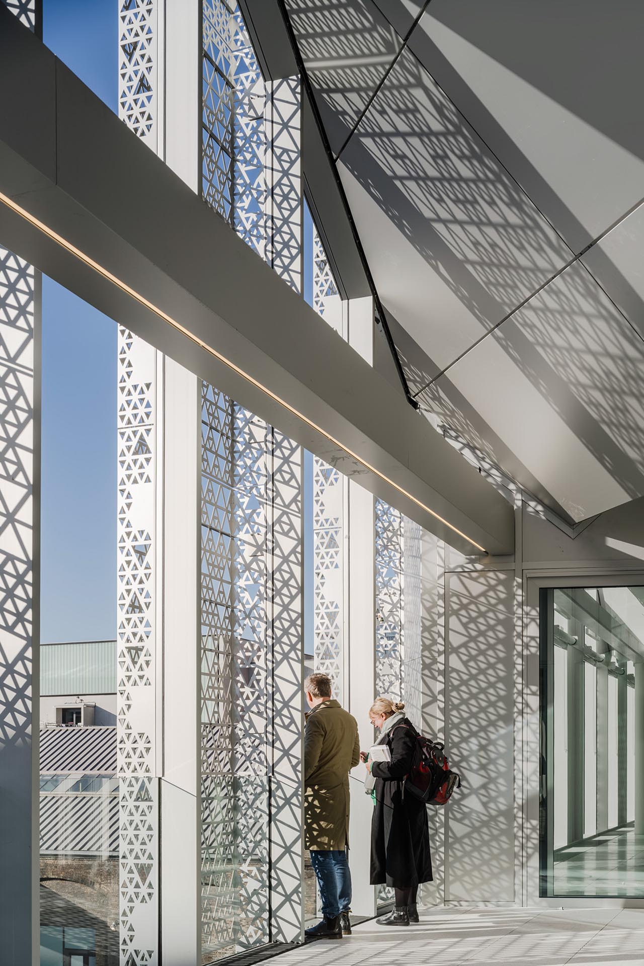 Die kunstvolle Perforation der Aluminiumfassade schafft ein faszinierendes Spiel aus Licht und Schatten.