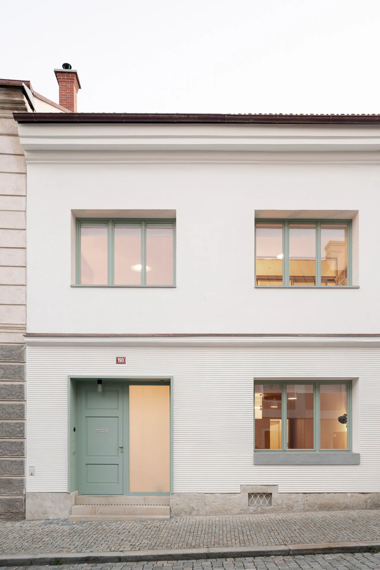 Die Fassade des sanierten Wohnhauses in Prag ist mit Strukturputz gestaltet.
