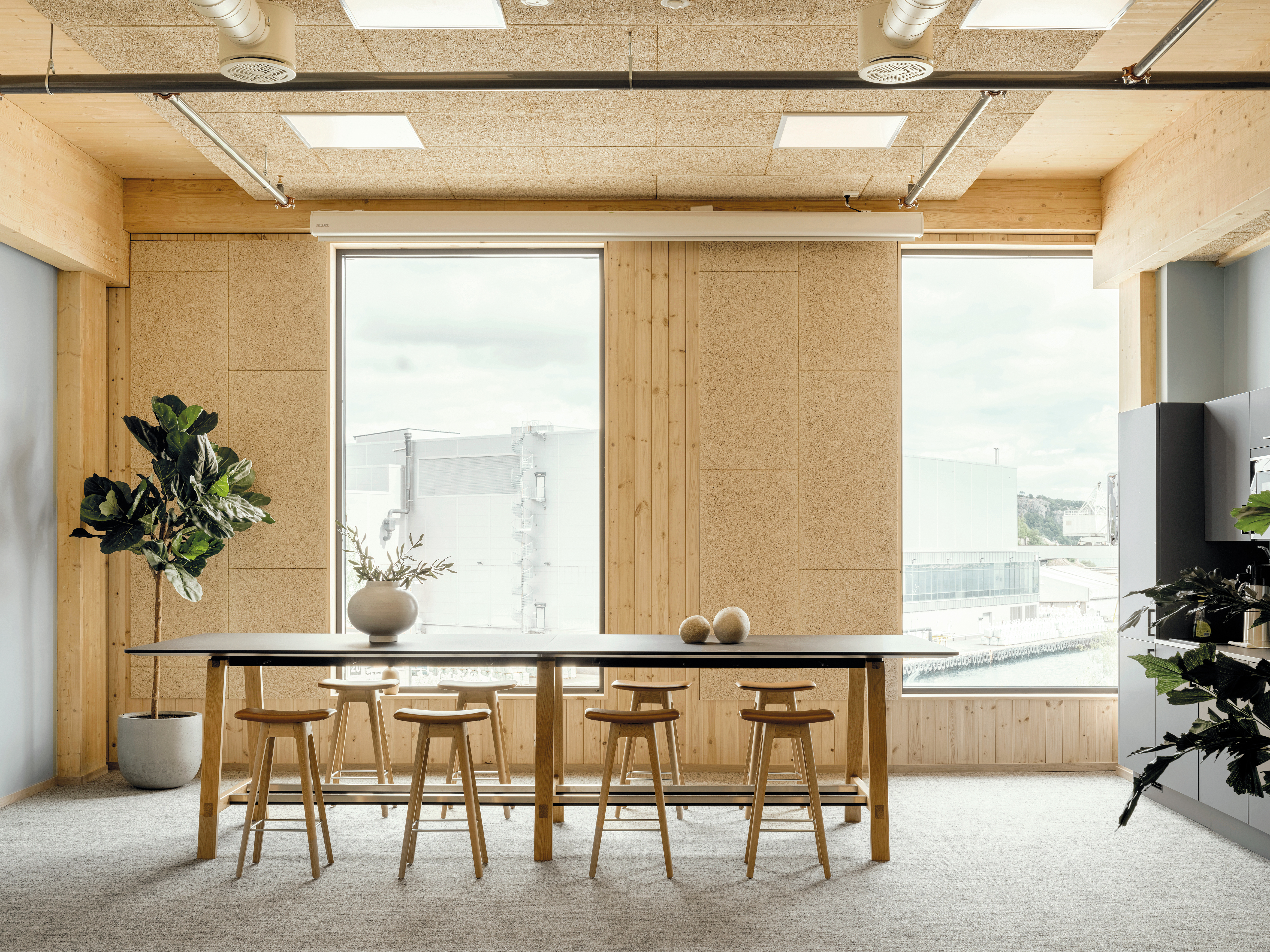 Das Gebäude mit grüner Holzfassade ist auch innen mit natürlichen Materialien gestaltet. Das Tragwerk ist eine Kombination aus Brettsperrholz und Brettschichtholz.