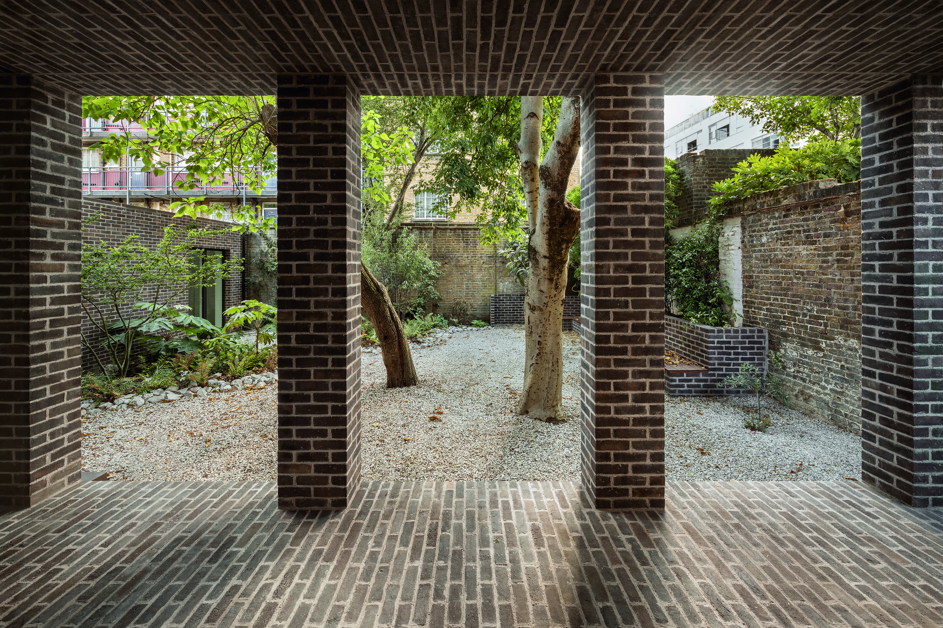 Das neue Mauerwerk der Loggia verwebt sich mit dem verwitterten Mauerwerk, das den Garten an drei Seiten umgibt.