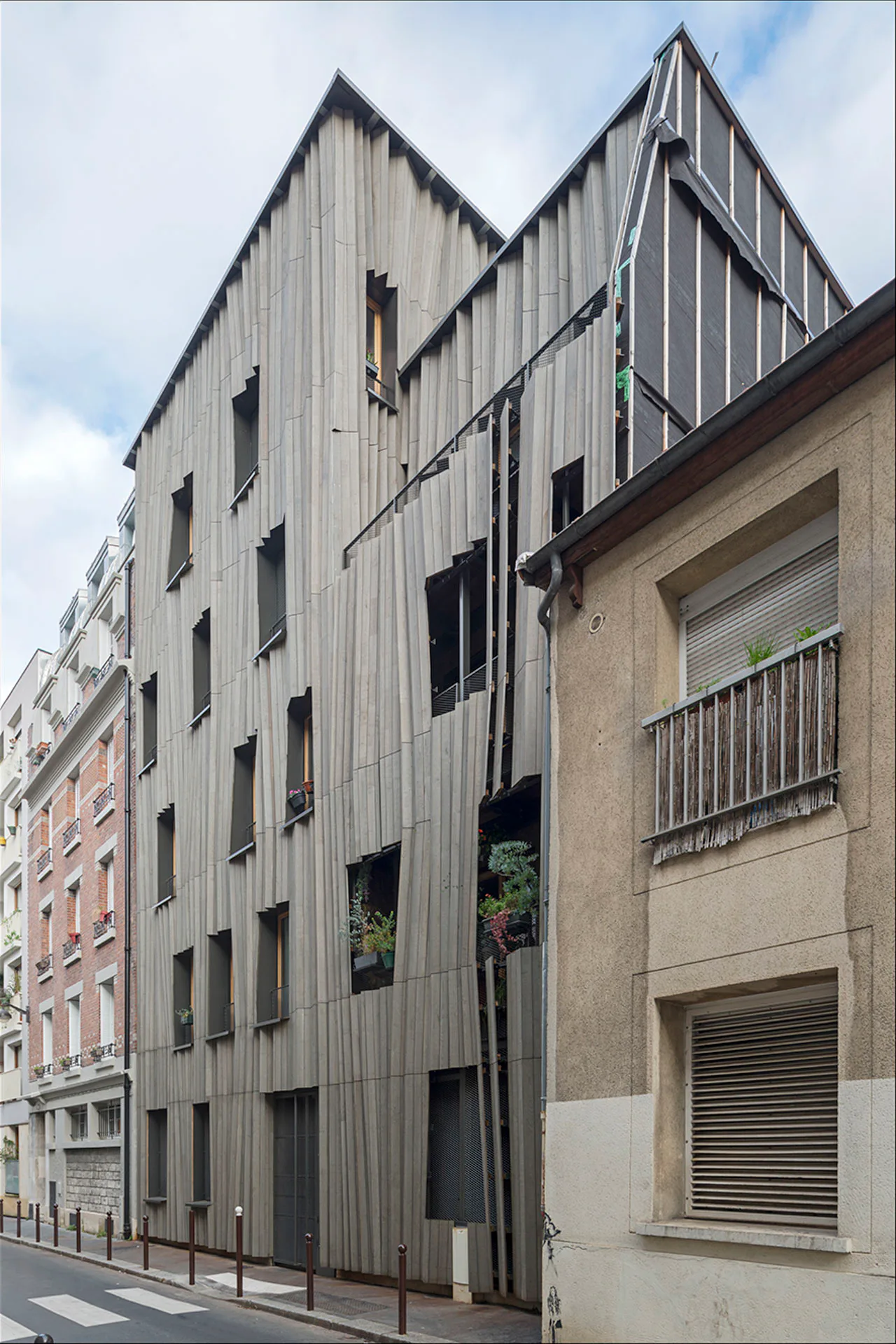 Faltenwurf: Mit origamiähnlichen Wellen und asymmetrischen Öffnungen hebt sich die Hauptfassade von Yama Tani deutlich von der Nachbarschaft ab.