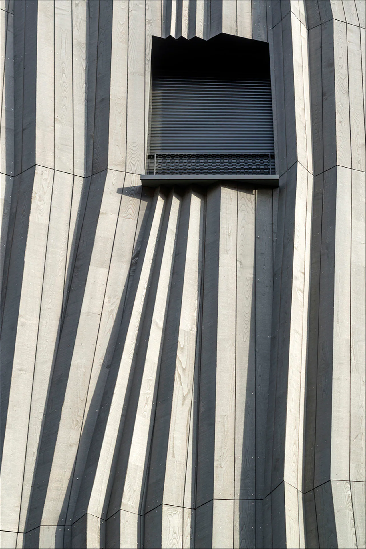 Faltenwurf: Mit origamiähnlichen Wellen und asymmetrischen Öffnungen hebt sich die Hauptfassade von Yama Tani deutlich von der Nachbarschaft ab.