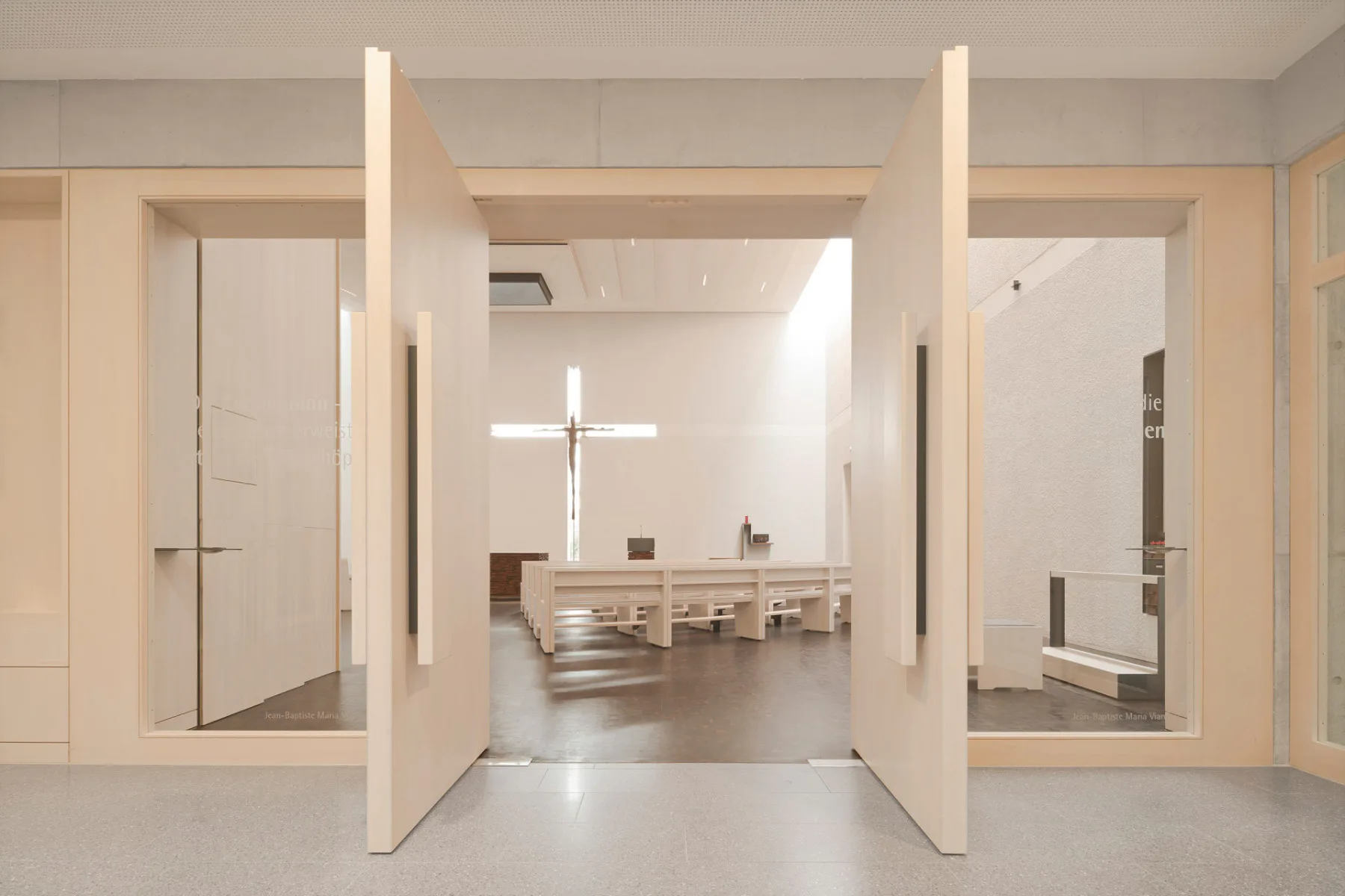 Im Innenraum des Neubaus kontrastieren helles Weißtannenholz, weißer Rauputz und eine weiß lasierte Holzdecke mit dem Fußboden aus dunklem Hirnholzparkett.