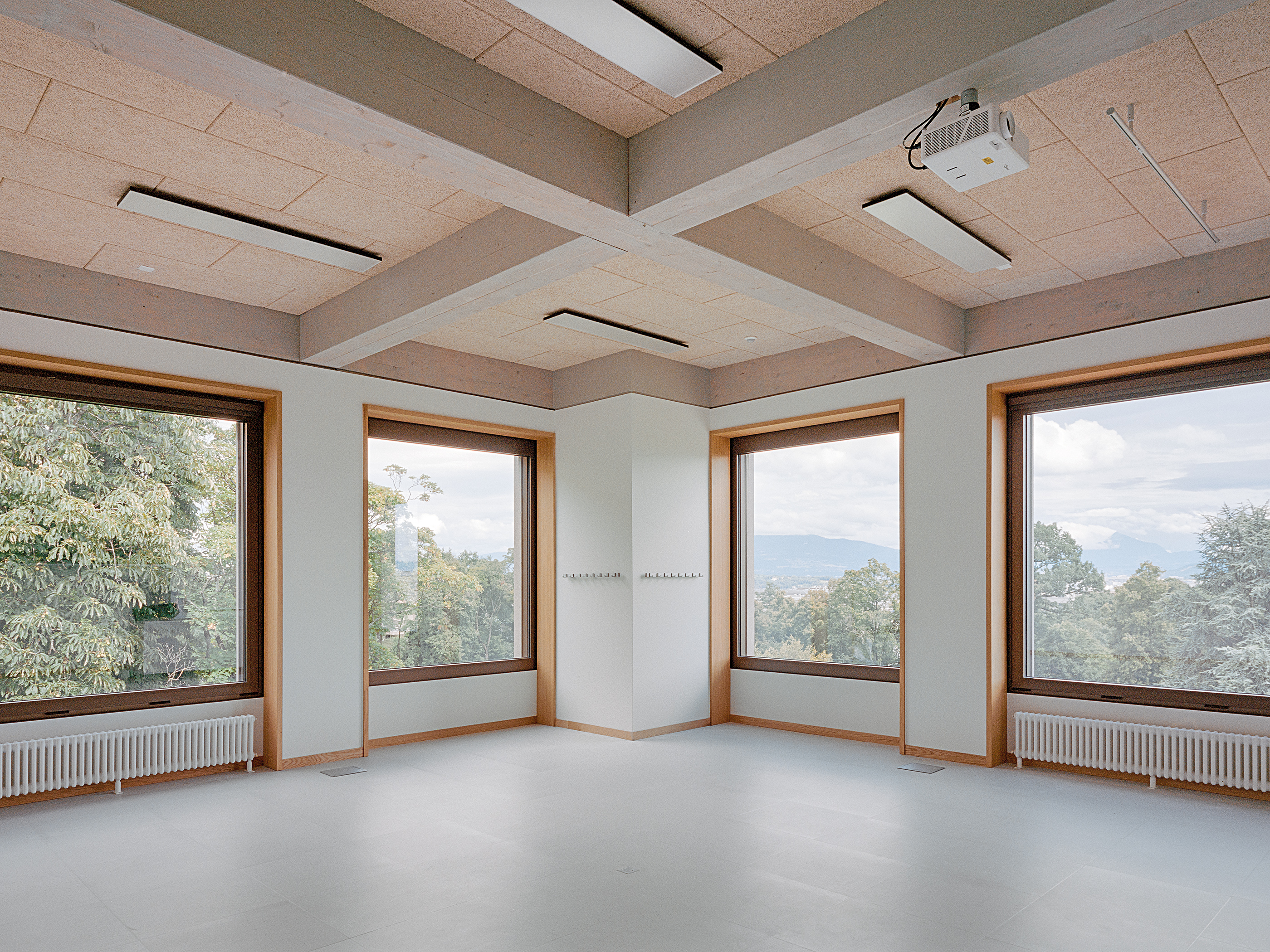Die Klassenräume in der Aufstockung unterscheiden sich von jenen im Bestand vor allem durch mehr Raumhöhe und das sichtbare Holztragwerk.