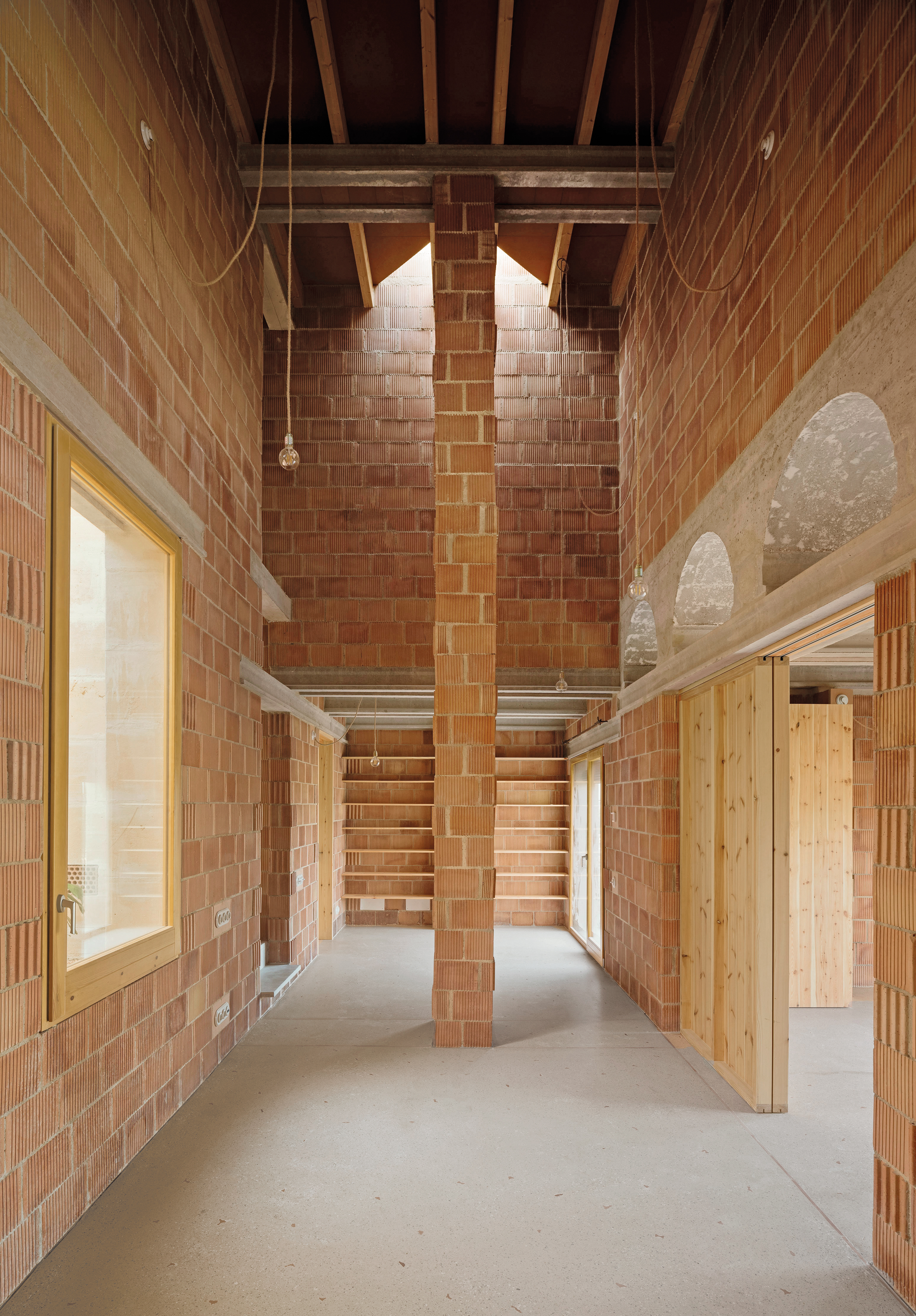 Hinter dem Hauseingang öffnet sich ein breiter und hoher Flur. Rechts liegen die Schlafzimmer der Töchter, links führen Treppen hinauf ins Wohnzimmer.