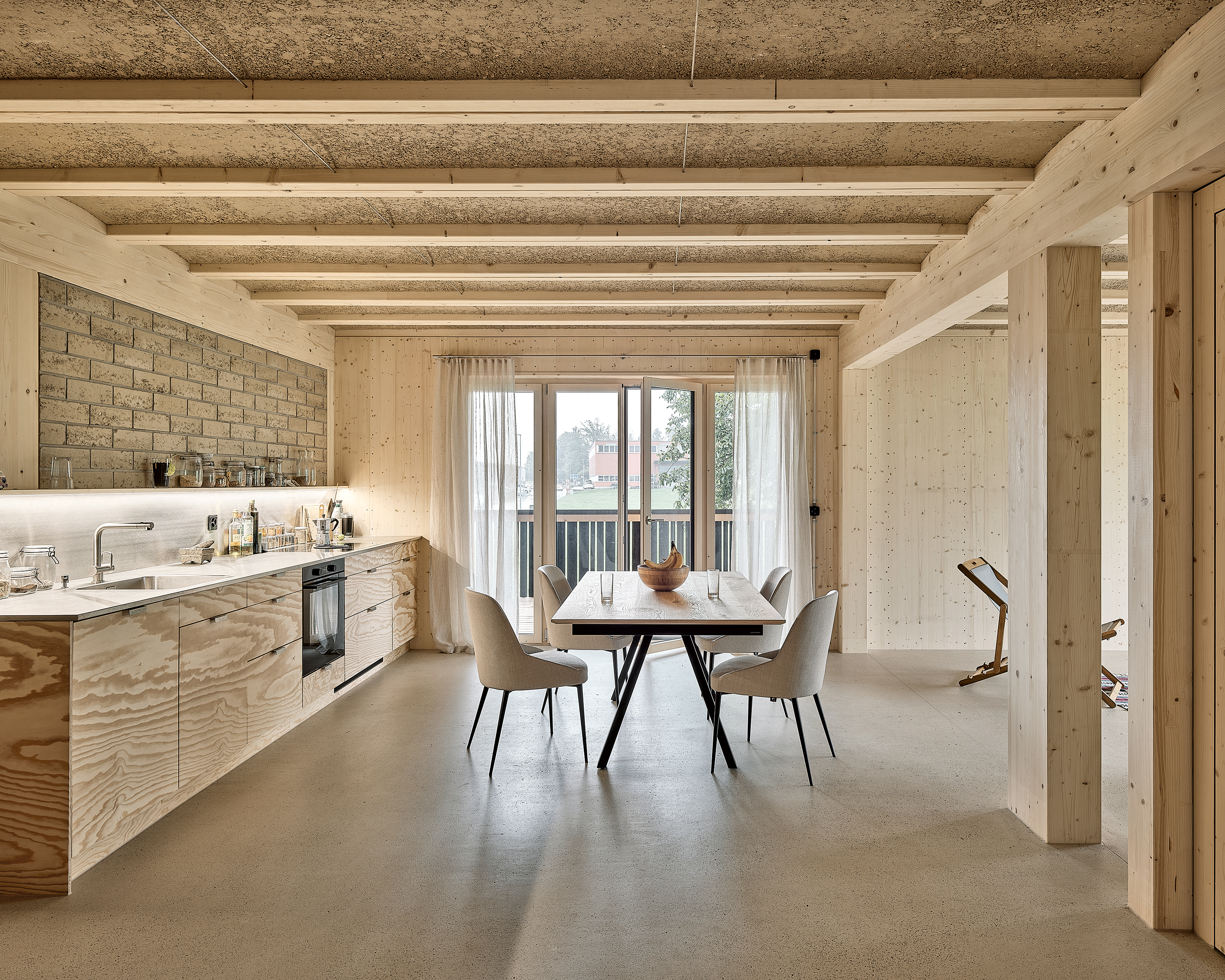 Das Mehrgenerationenhaus wurde als Holzrahmenbau mit robotergestampften Holz-Lehmdecken konstruiert. Die nicht tragenden Wandausfachungen bestehen aus Lehmziegeln.