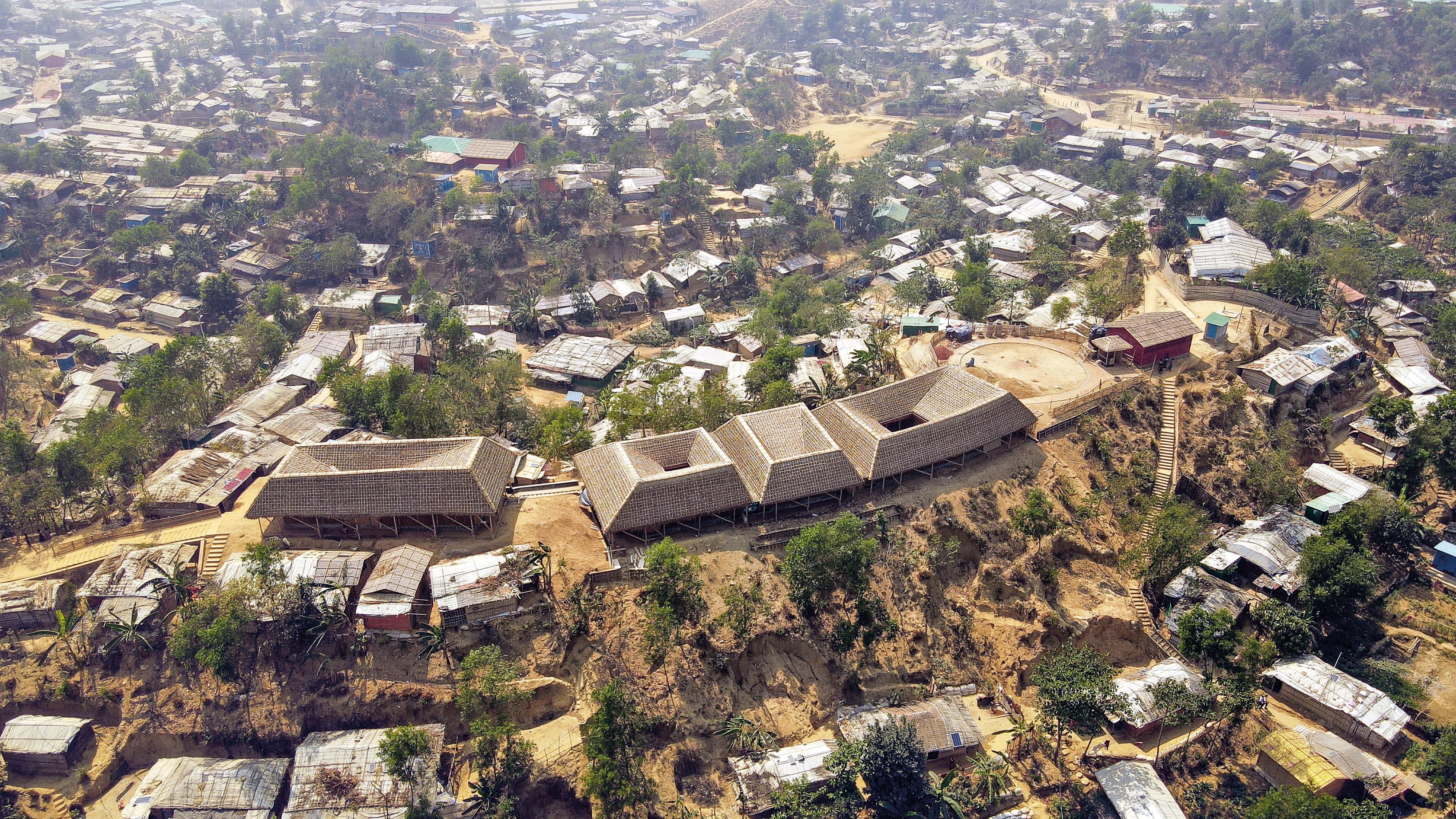 Das Rohingya-Kulturzentrum steht auf einer kleinen Anhöhe mitten im Camp. Vier weit ausladende, mit Palmblättern gedeckte Dächer umgeben geräumige Innenhöfe. Die Außenwände bestehen aus Bambus.