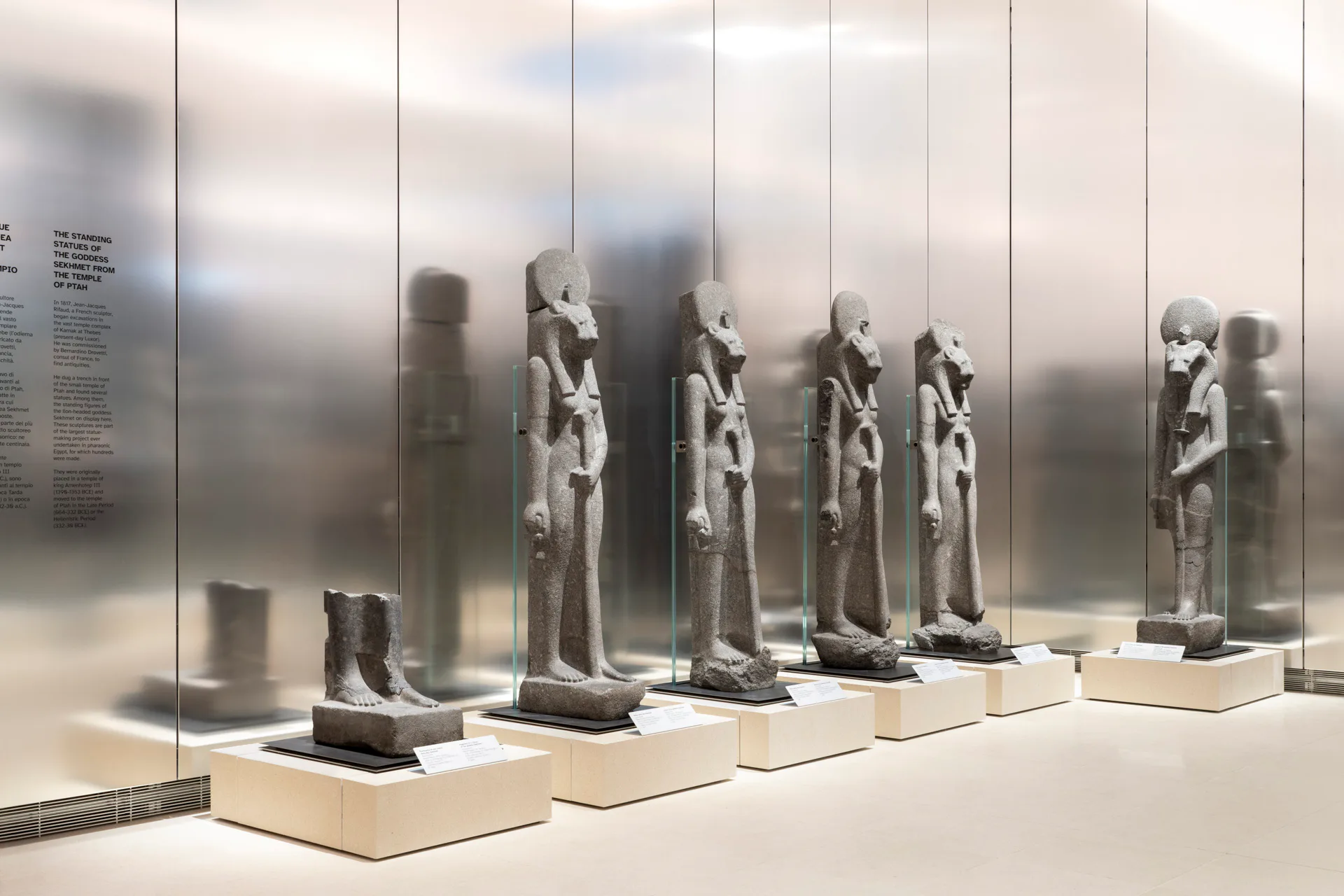 Dezent spiegelnde Aluminiumwände bilden den Hintergrund für die Statuen.