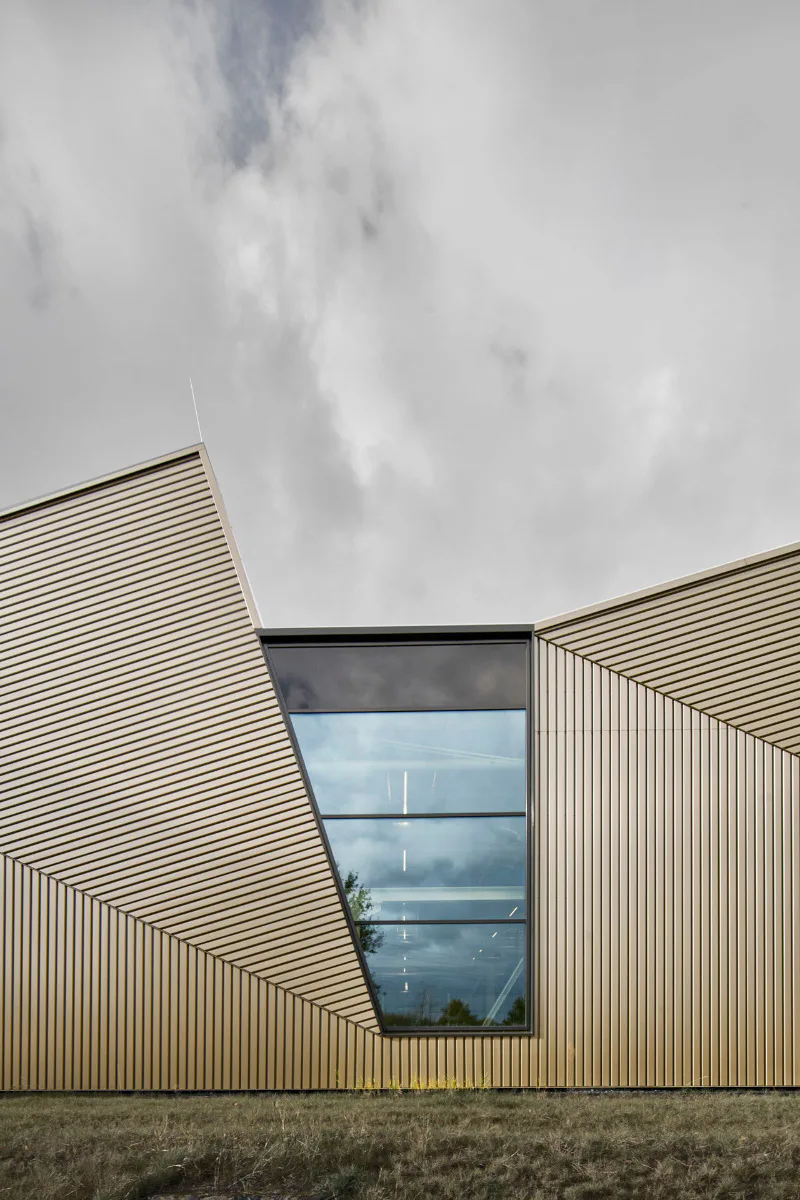 Die Form des Sheddachs zeichnet sich in der Fassade ab.