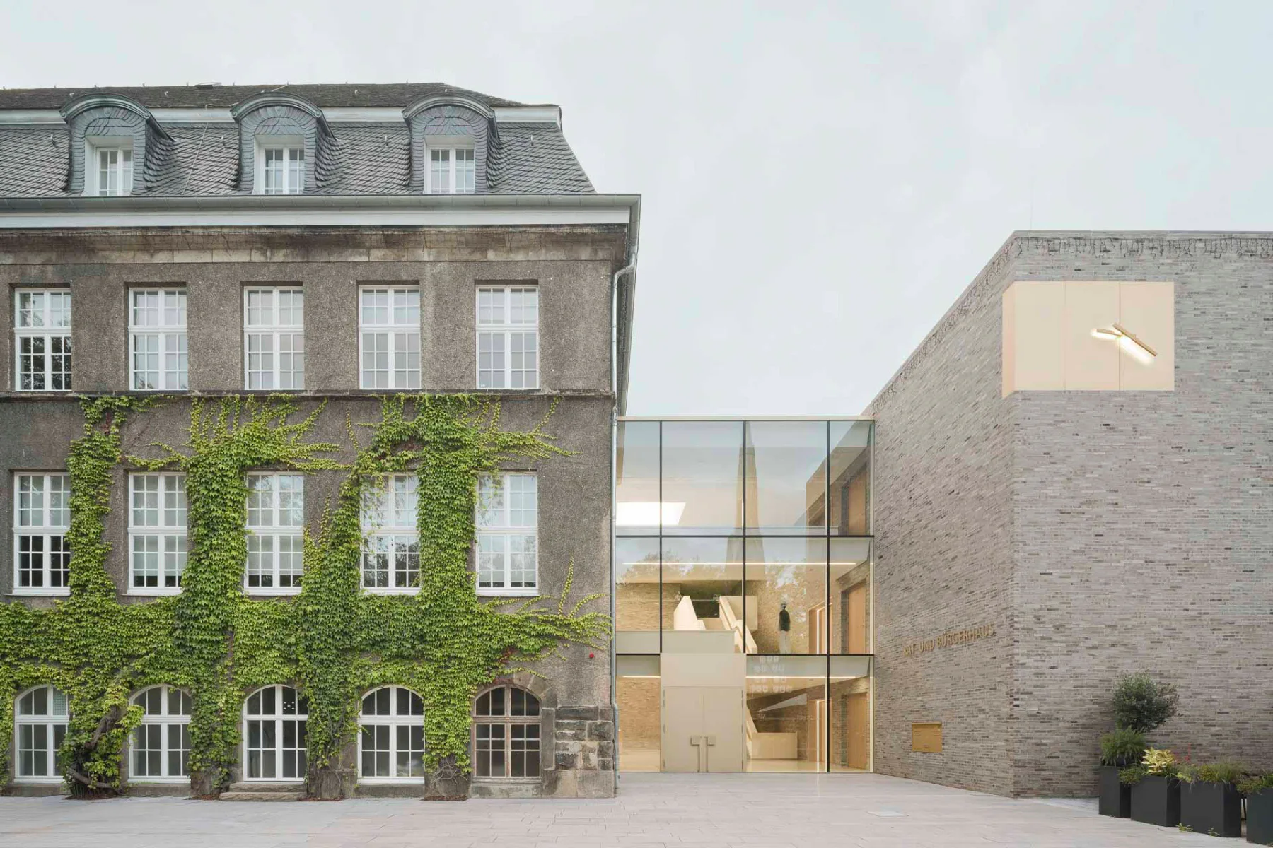 Alt- und Neubau des Holzwickeder Rathauses sind durch breite Glasfugen getrennt.