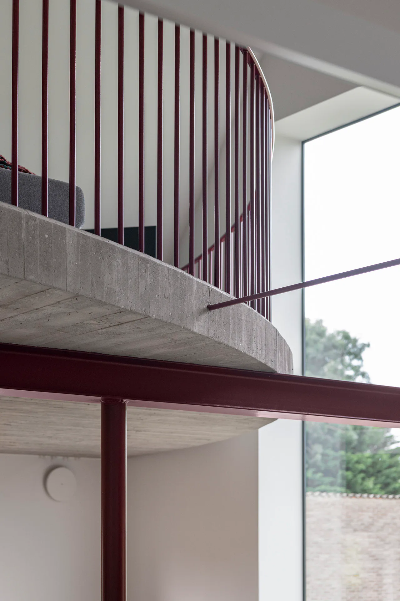 Filigrane rote Stahlträger unterstützen die Galerie aus Ortbeton.