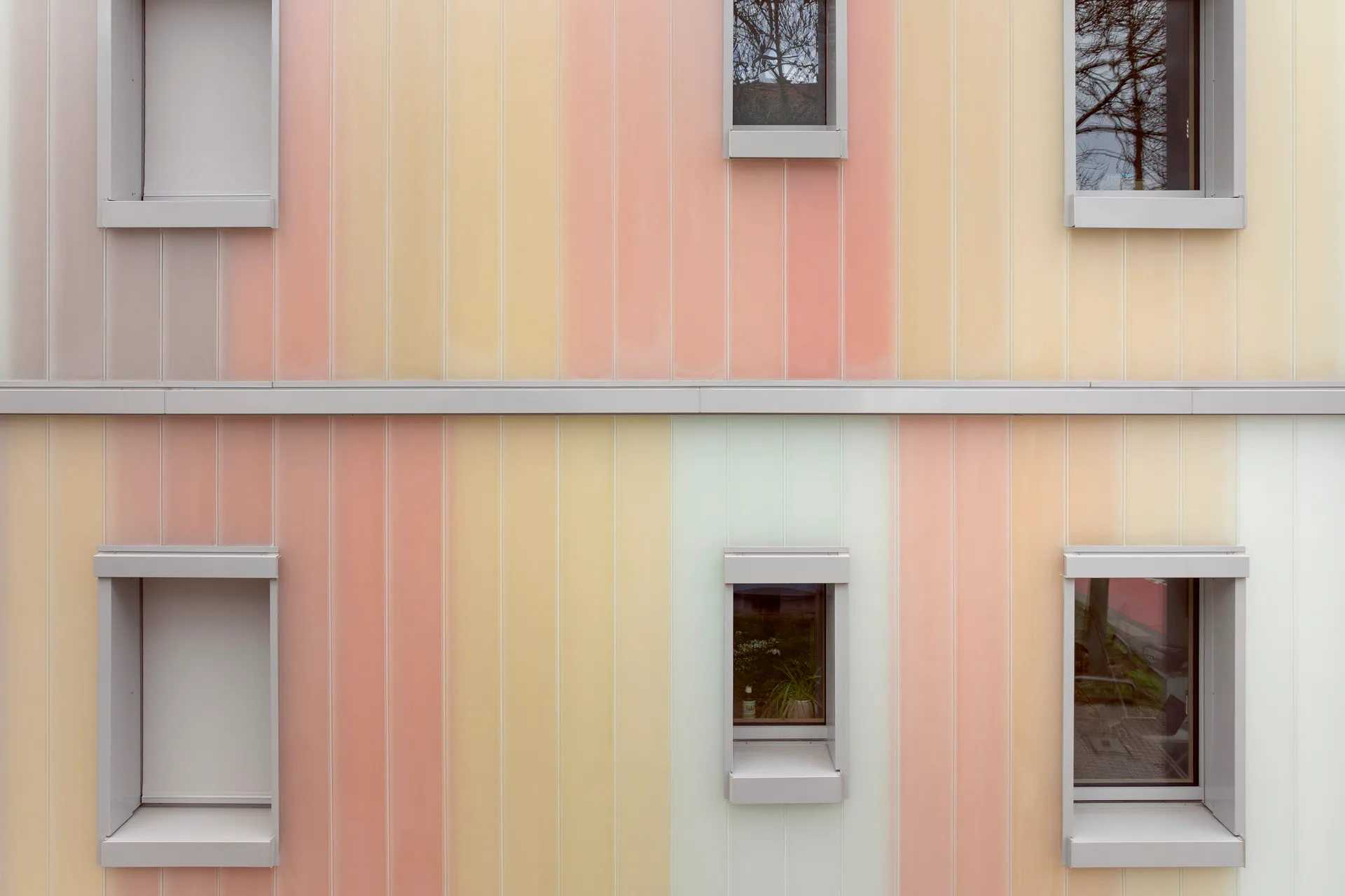 Die Farbflächen schimmern durch die transluzente Außenhaut aus Profilbauglas.