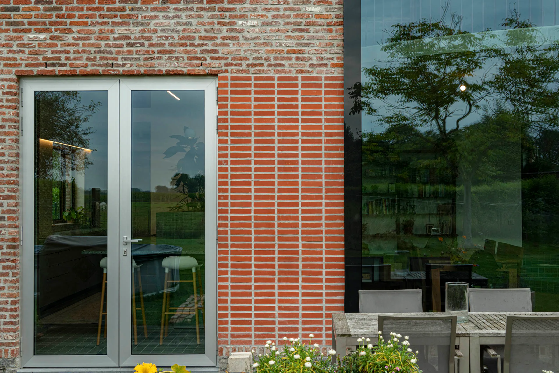 Neue großformatige Fensteröffnungen kontrastieren mit der traditionellen Backsteinfassade.